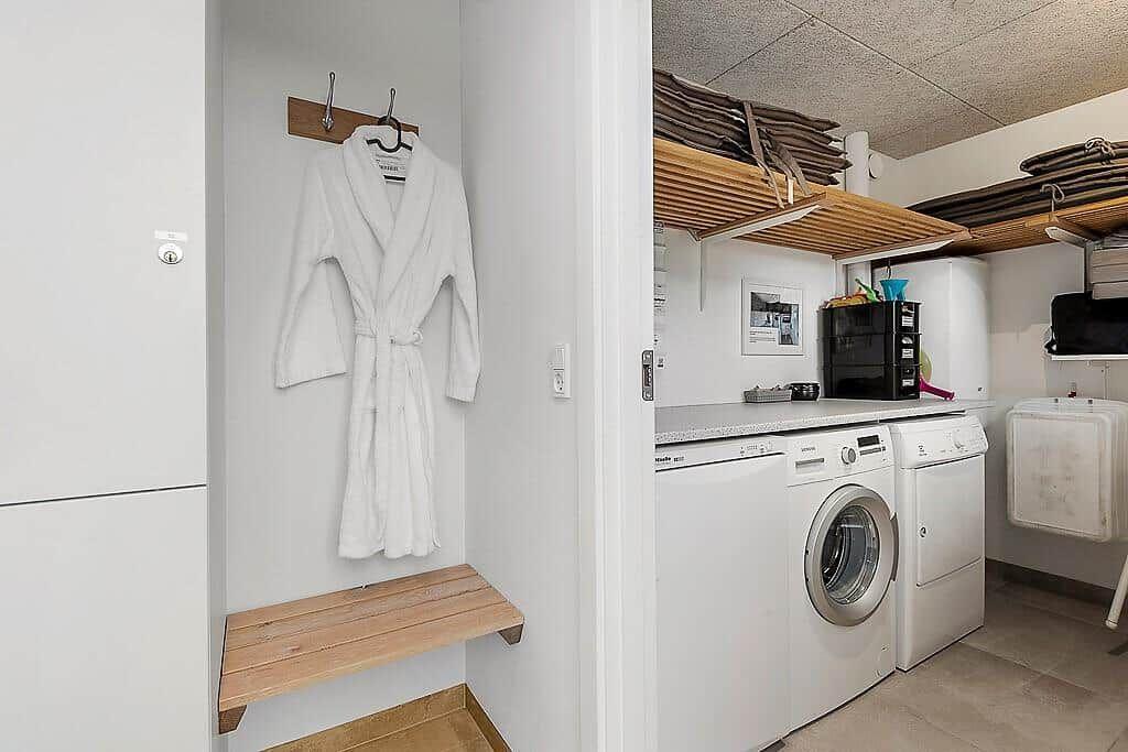 Laundry room with washer, dryer, and robe hanging on wall