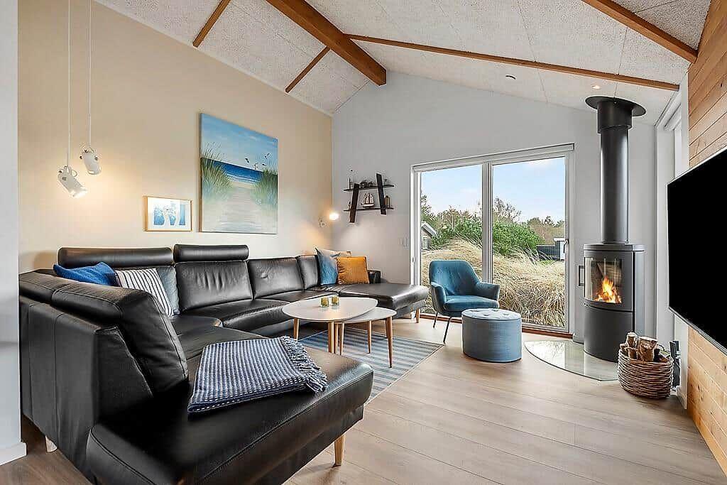 Living room with sofa, fireplace, and view of grassland.