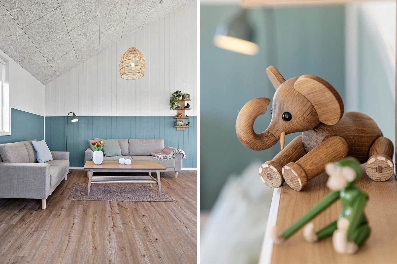 Wohnzimmer mit Sofa, Couchtisch und Holzboden. Holzfigur eines Elefanten auf Tisch.