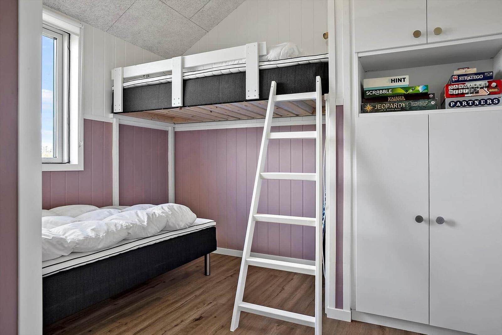 Zimmer mit Hochbett, Doppelbett und Kleiderschrank mit Brettspielen.