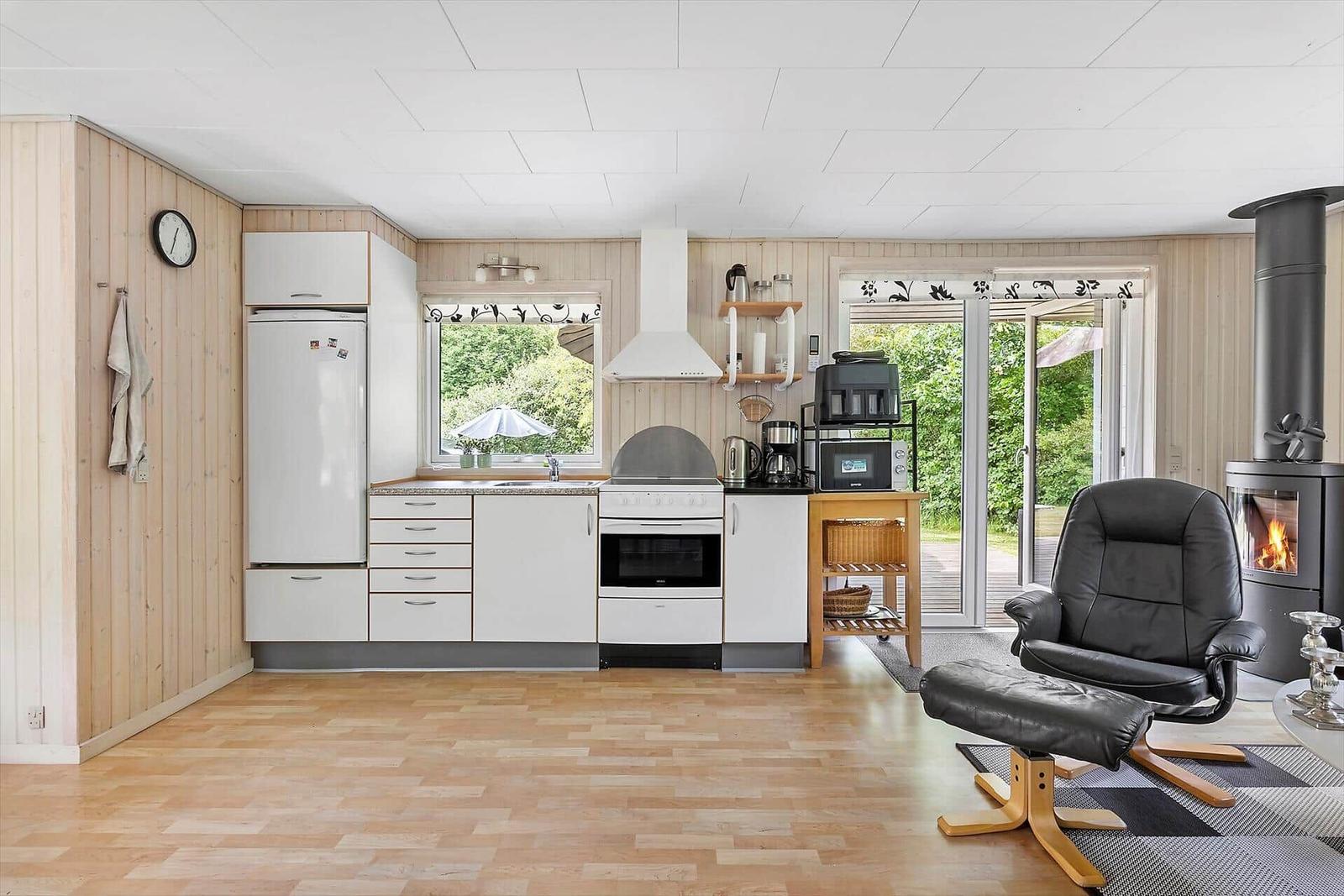 Kitchen with white cabinets, fireplace, and black leather chair