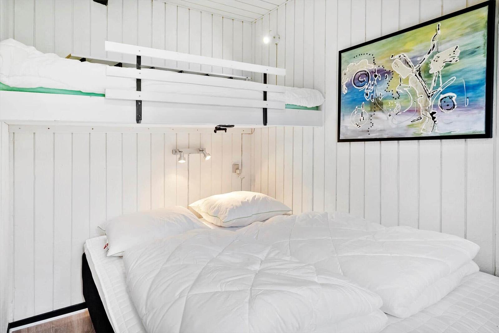 Zimmer mit Doppelbett und Hochbett, Wandbild und Leselampe