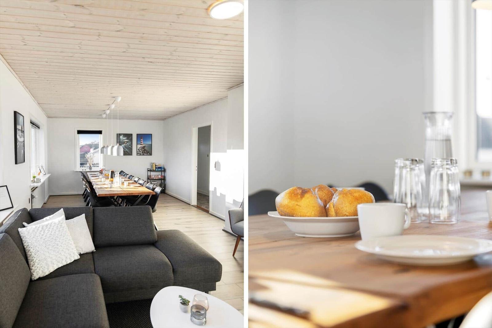 Living and dining area with sofa, table, and bread. Wooden ceiling and bright ambiance.