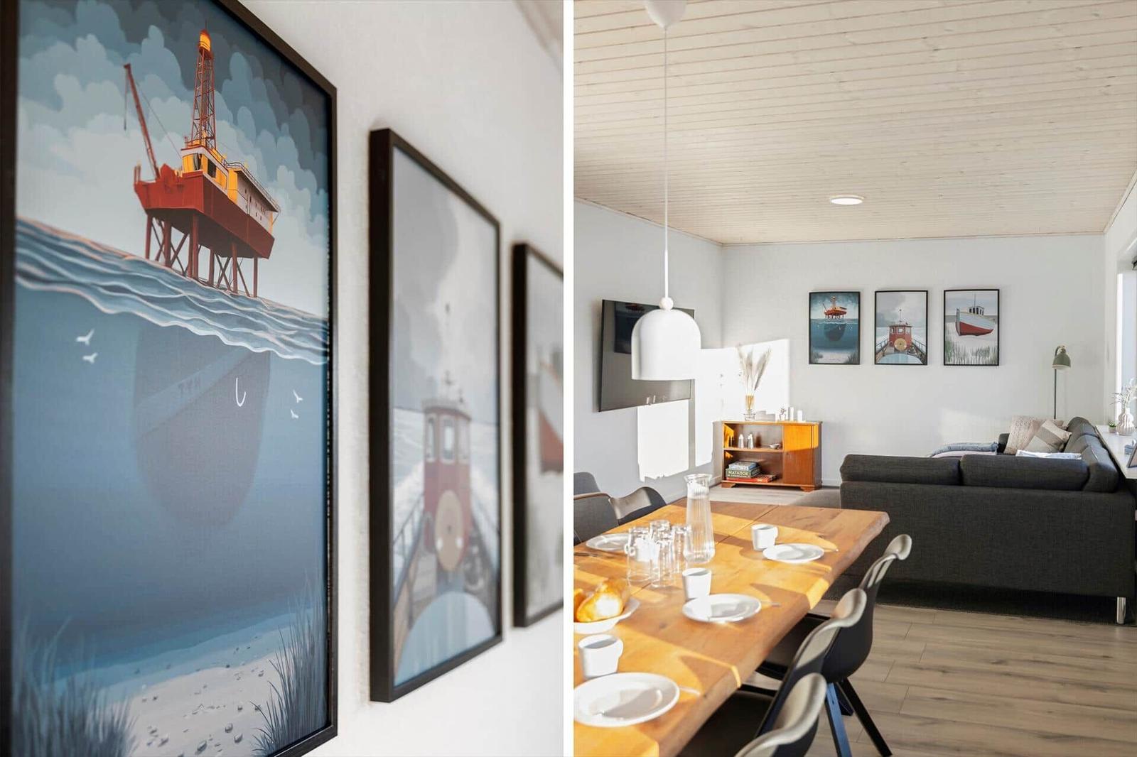 Dining room with wooden table and sofa. Wall art shows ships and platforms.