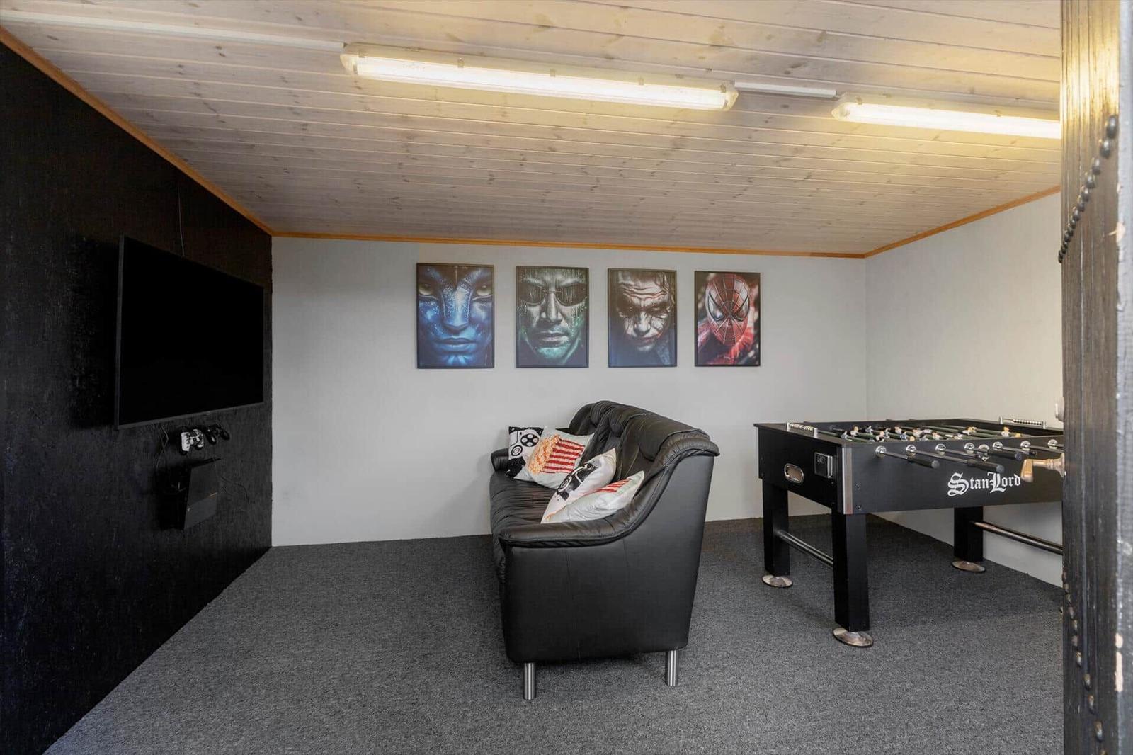 Room with sofa, foosball table, and wall art