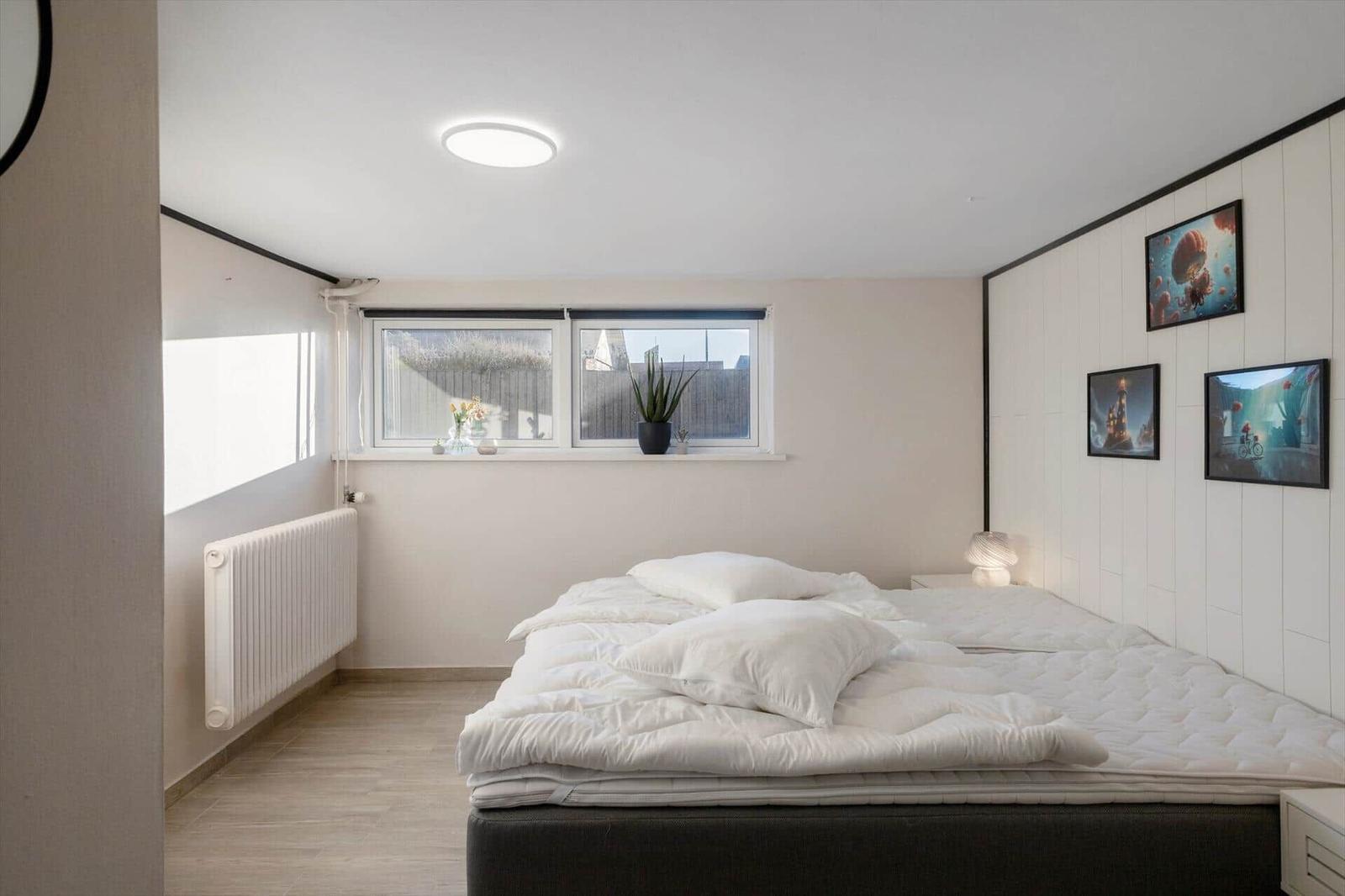 Bedroom with bed, window, and wall art.