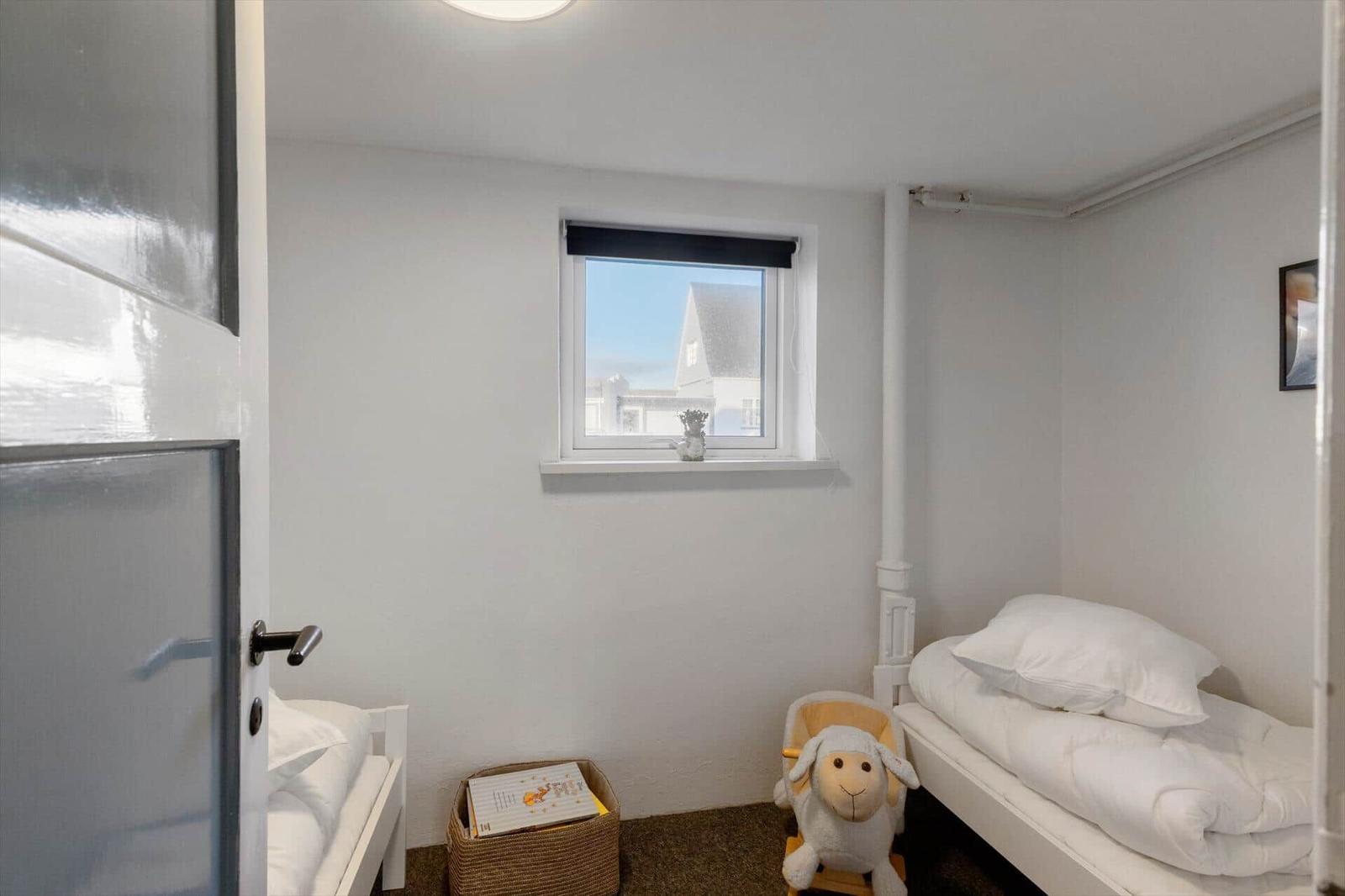 Room with two beds, window and rocking chair with sheep