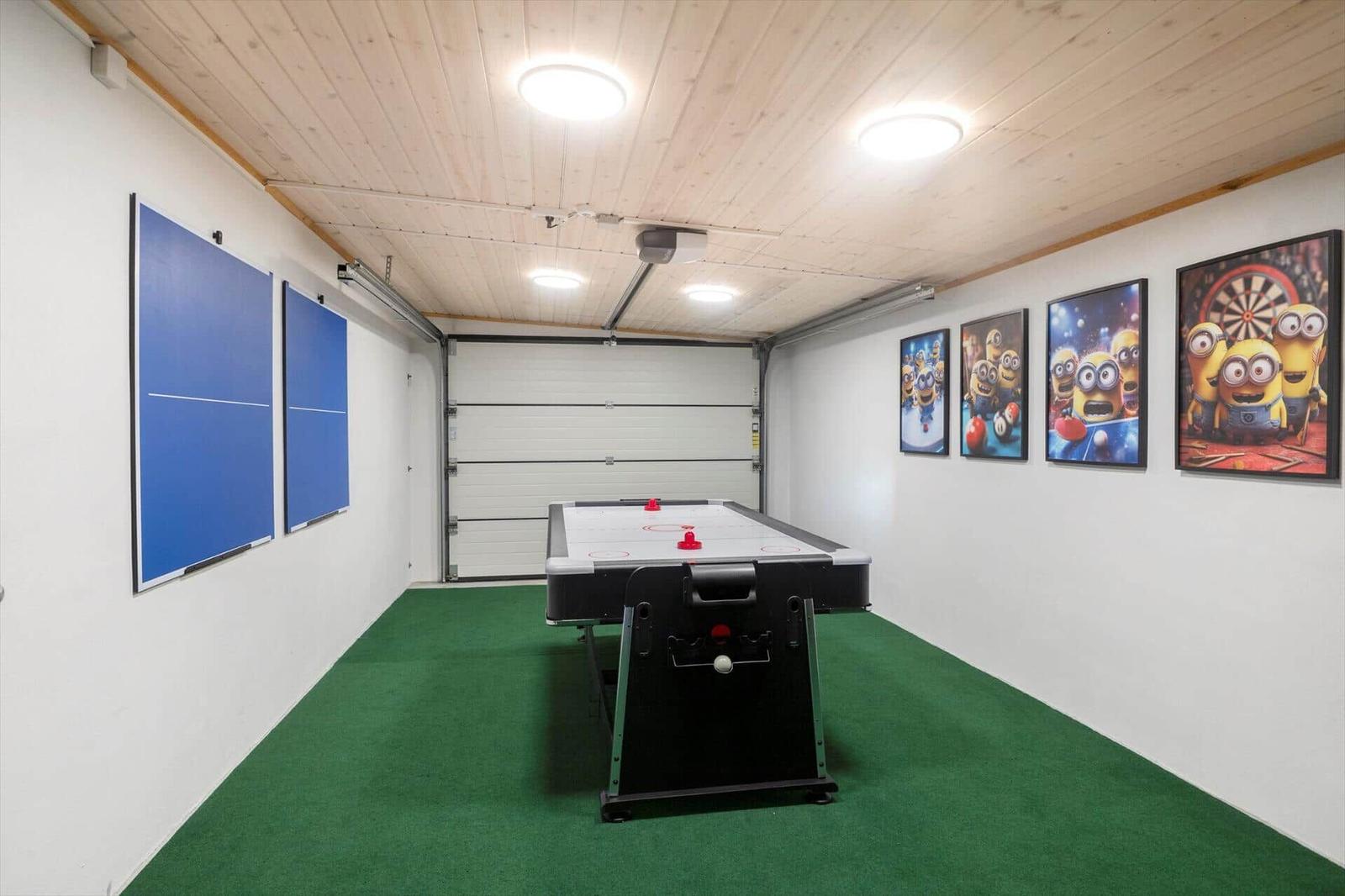 Room with air hockey table, ping pong and Minion pictures on the wall.