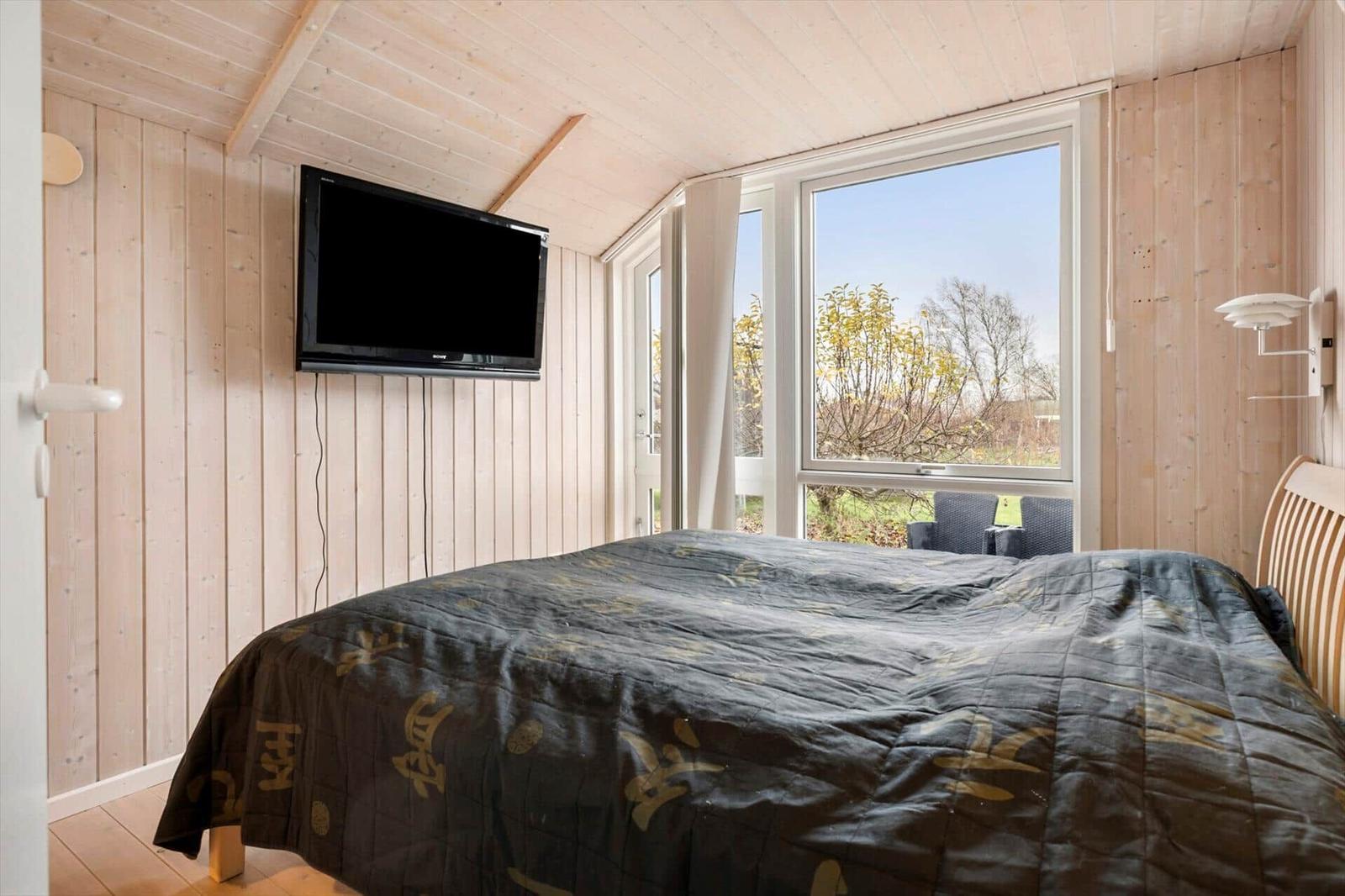 Bedroom with bed, TV, and large window for views.
