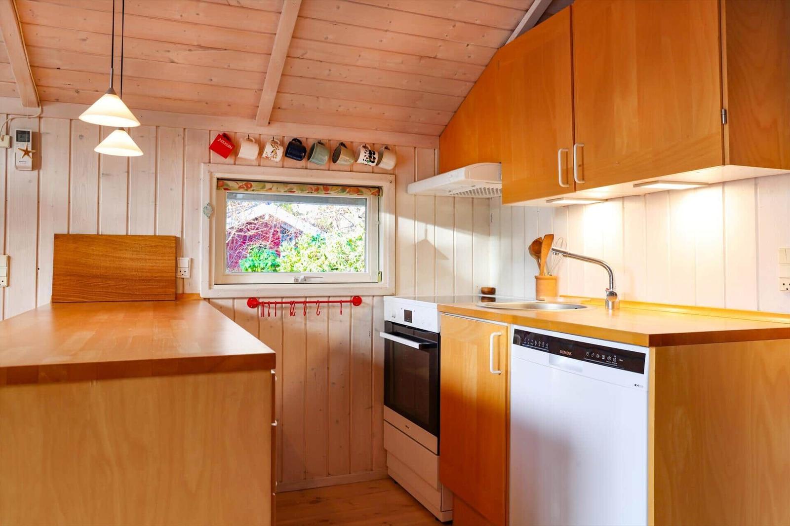 Kitchen with wooden surfaces, window, and integrated appliances.
