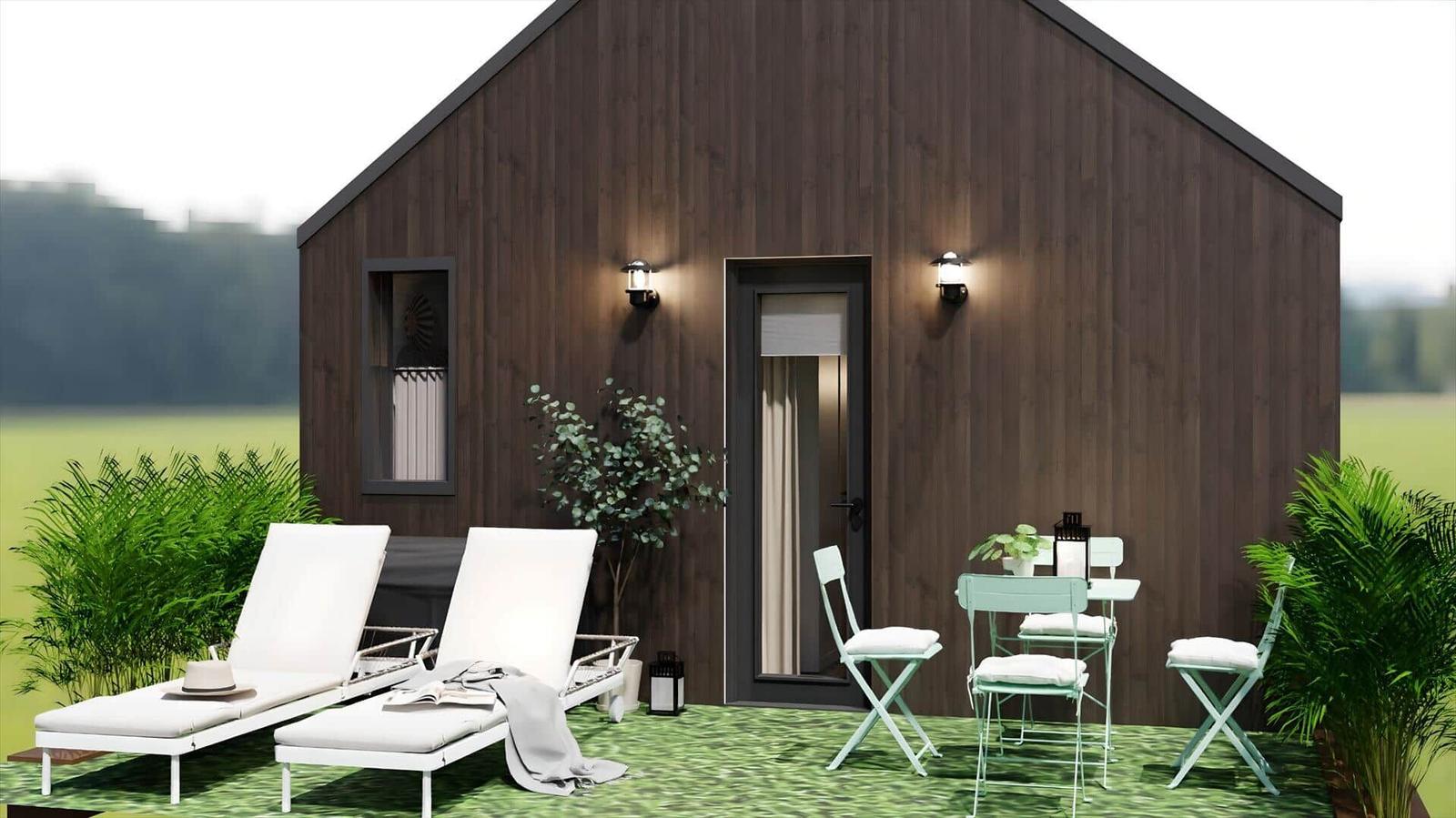 Modern wooden cabin with outdoor terrace, loungers, and table with chairs.