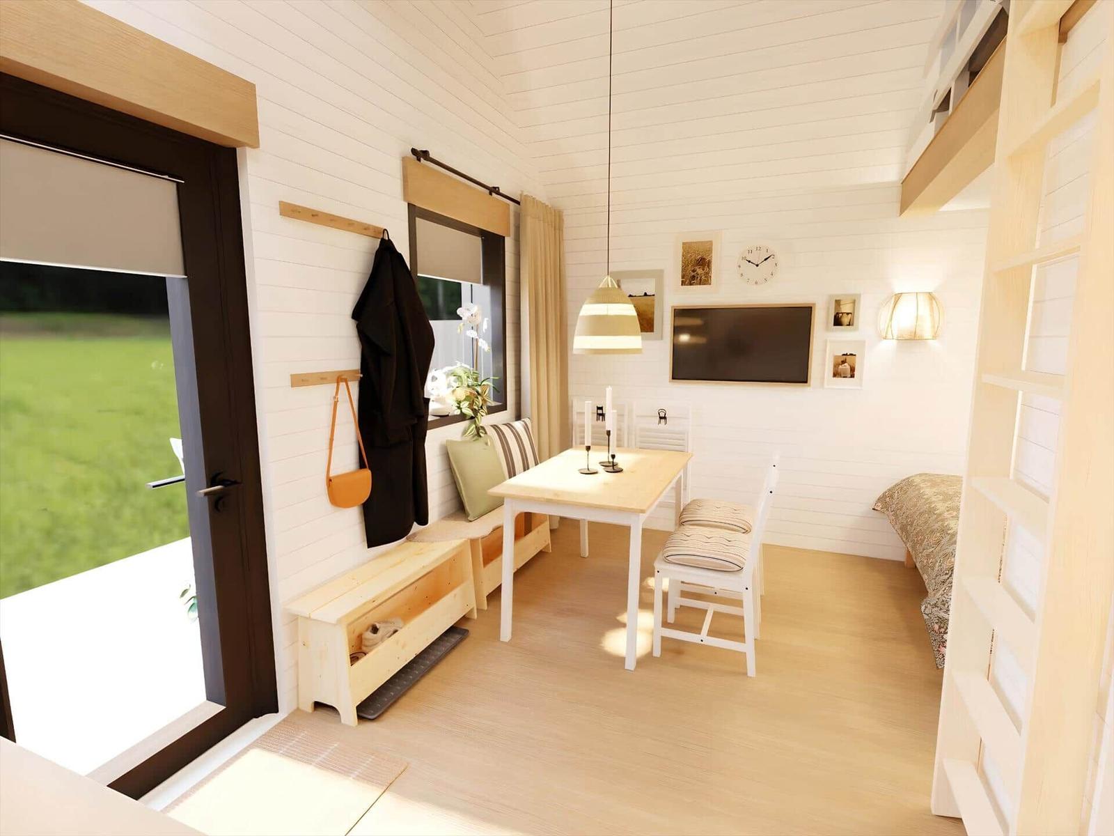 A room with a table, chairs, TV, and sleeping area. A clock and pictures hang on the wall.