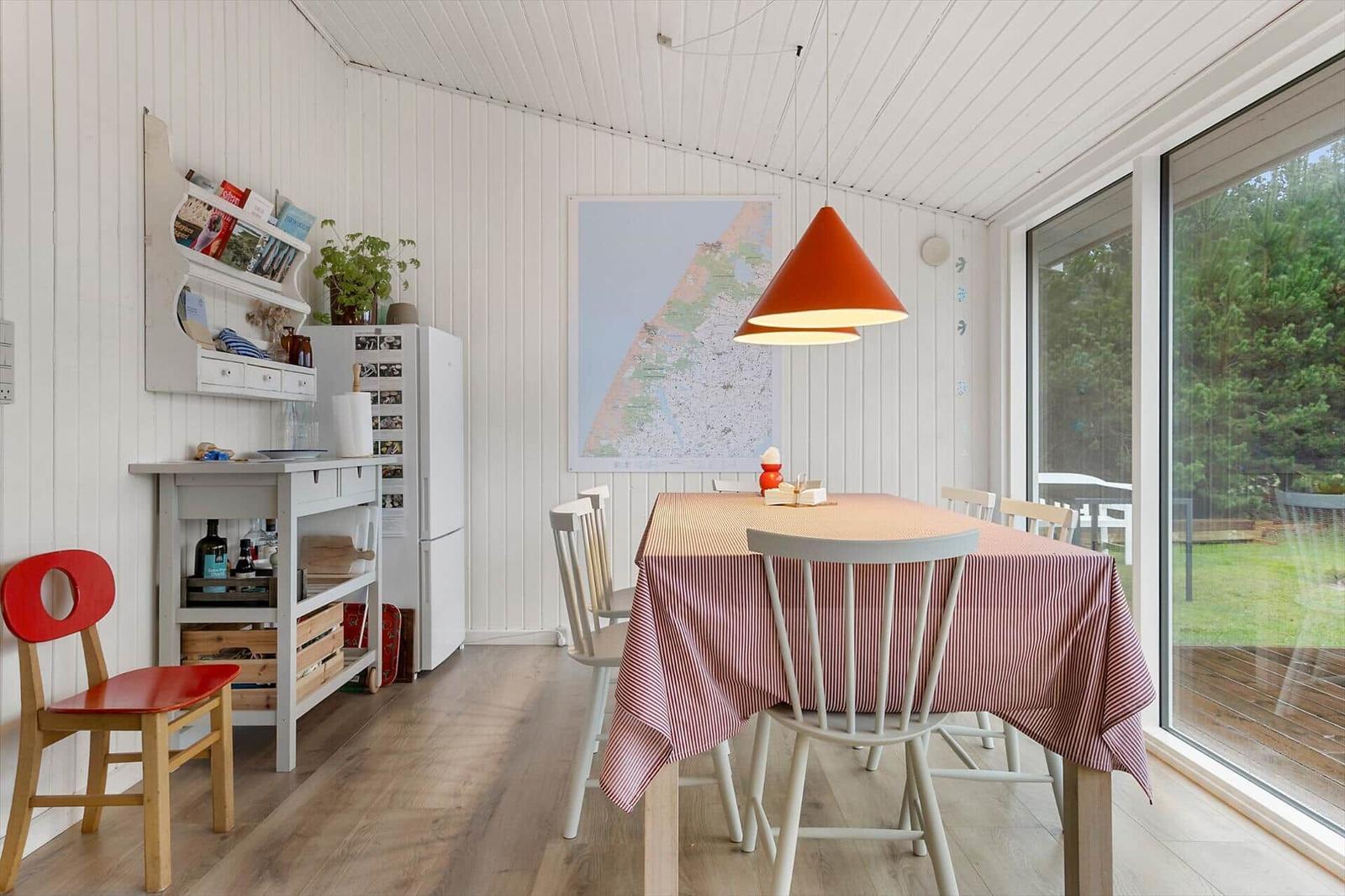 Esszimmer mit Tisch, Stühlen und Fenster zur Terrasse.