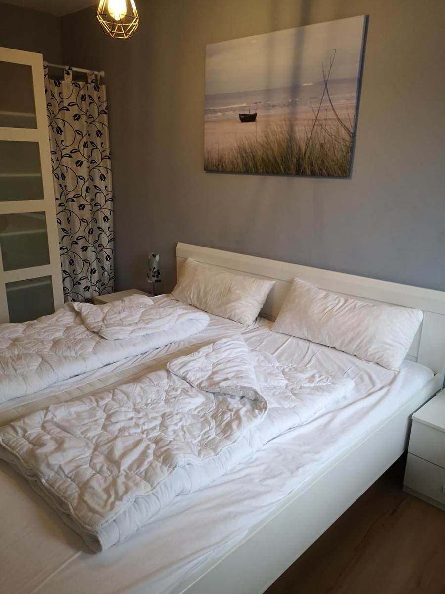 Schlafzimmer mit Doppelbett, Wandbild und Nachttisch.