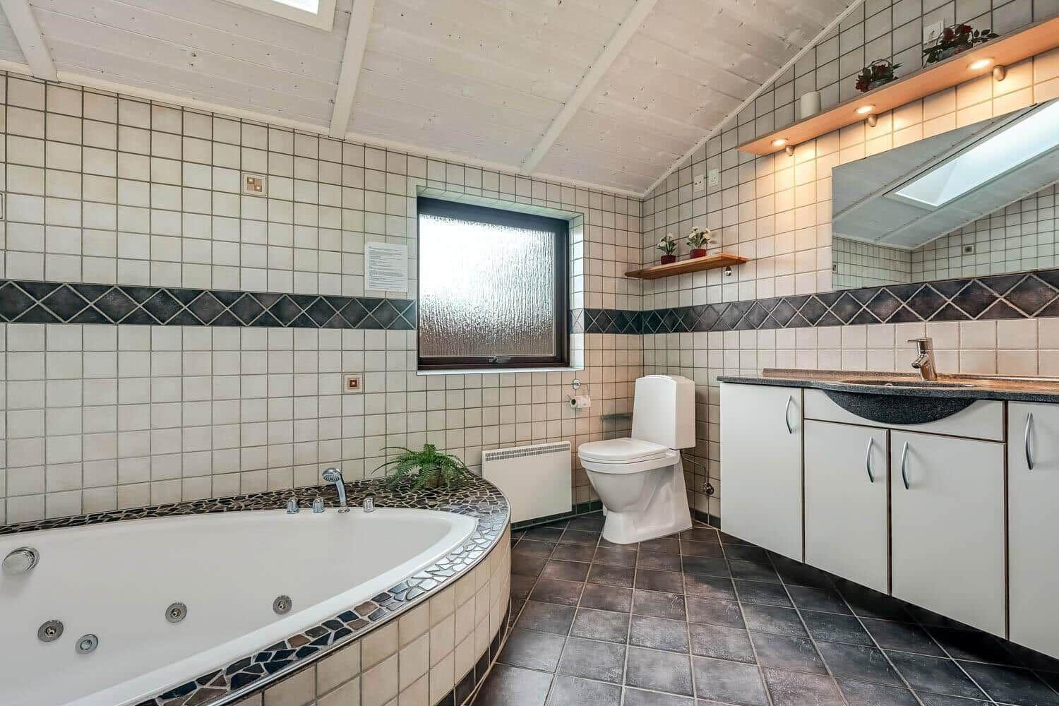 Bath with whirlpool, toilet, and sink with mirror