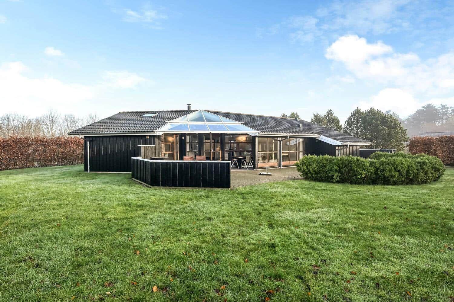 A house with a large garden and glass roof over the terrace.