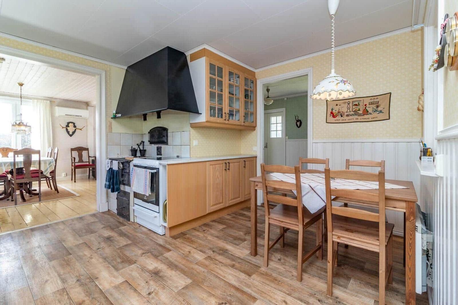 Küche mit Essbereich, Holzfußboden und hölzernem Tisch mit Stühlen.