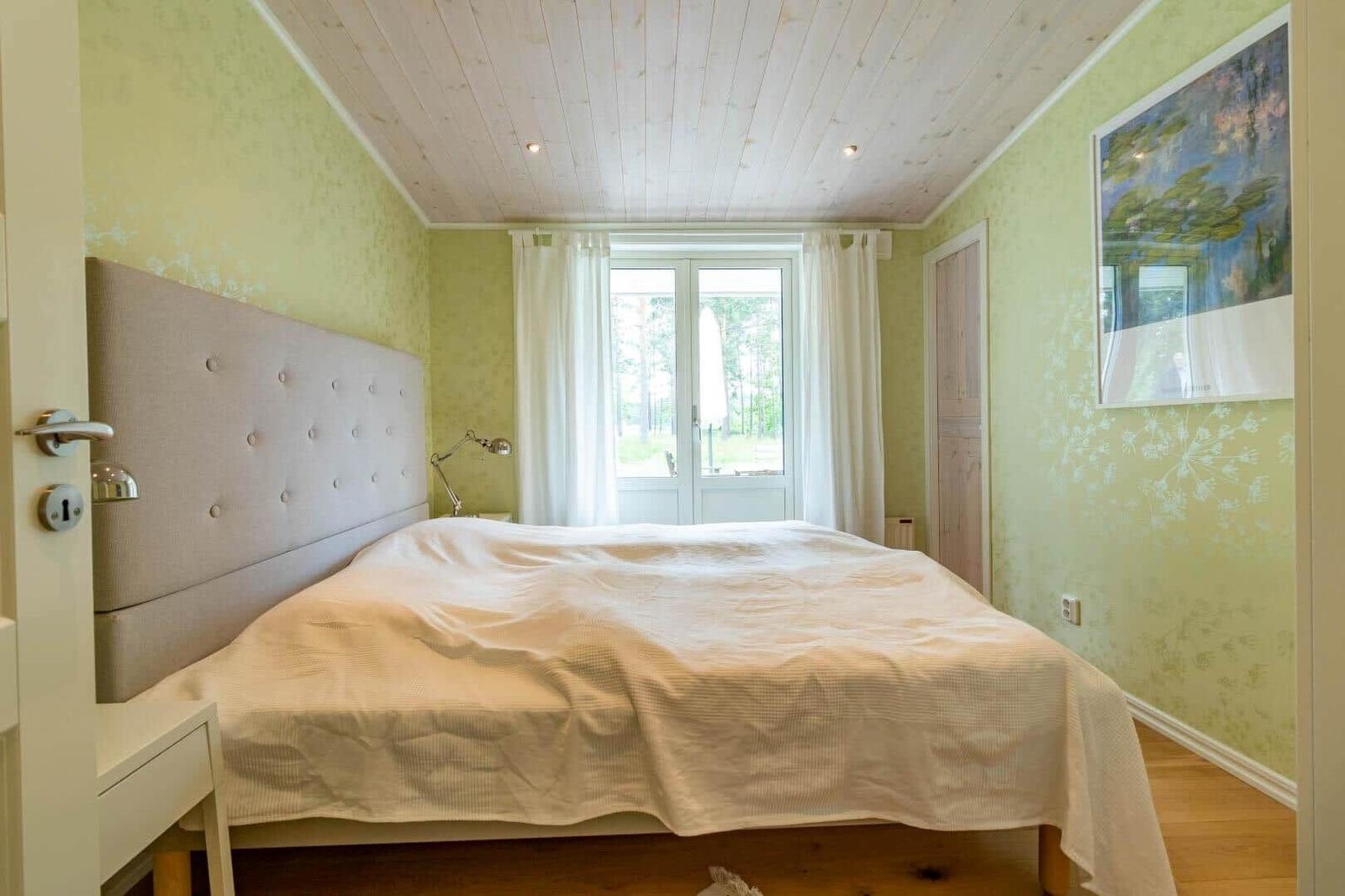 Bedroom with bed, window, and wall art.