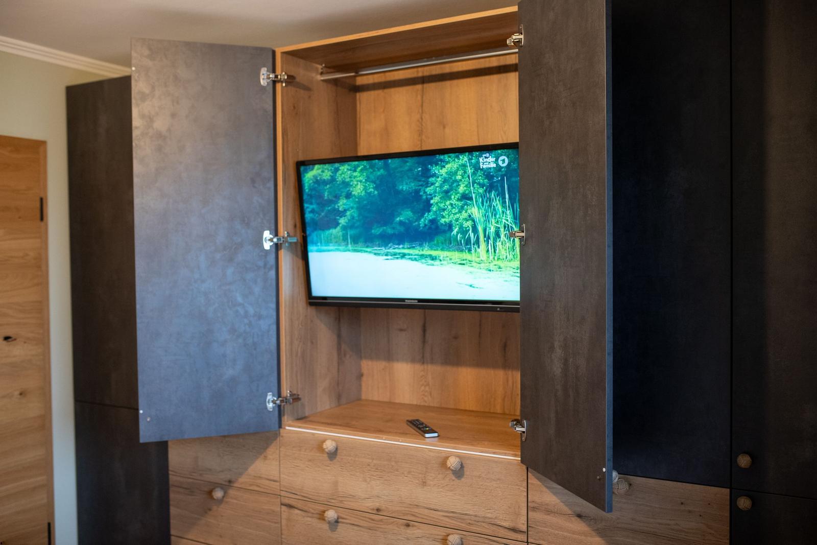TV in integriertem Schrank mit Holzoptik und Fernbedienung