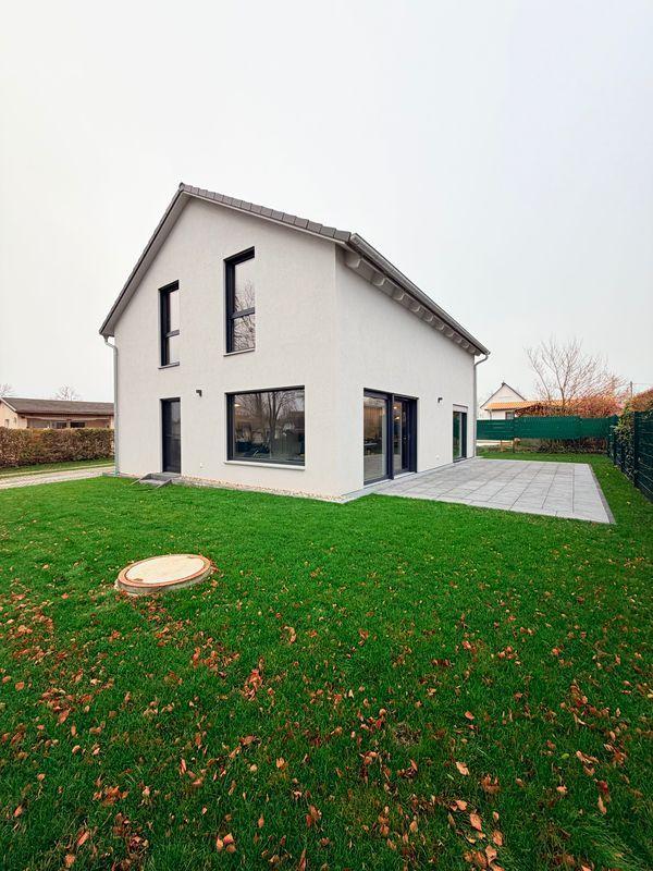 Moderne weiße Villa mit großem Garten und Terrasse.