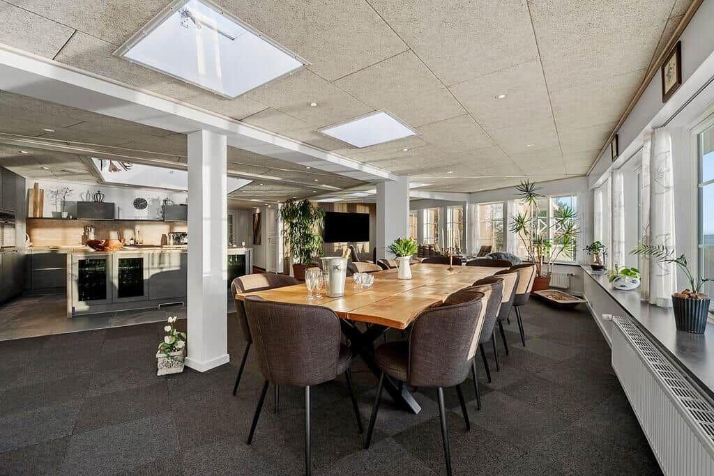 Large dining area with wooden table, chairs, and view of the kitchen.