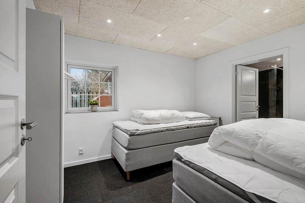 Room with two beds, window, and door to hallway.