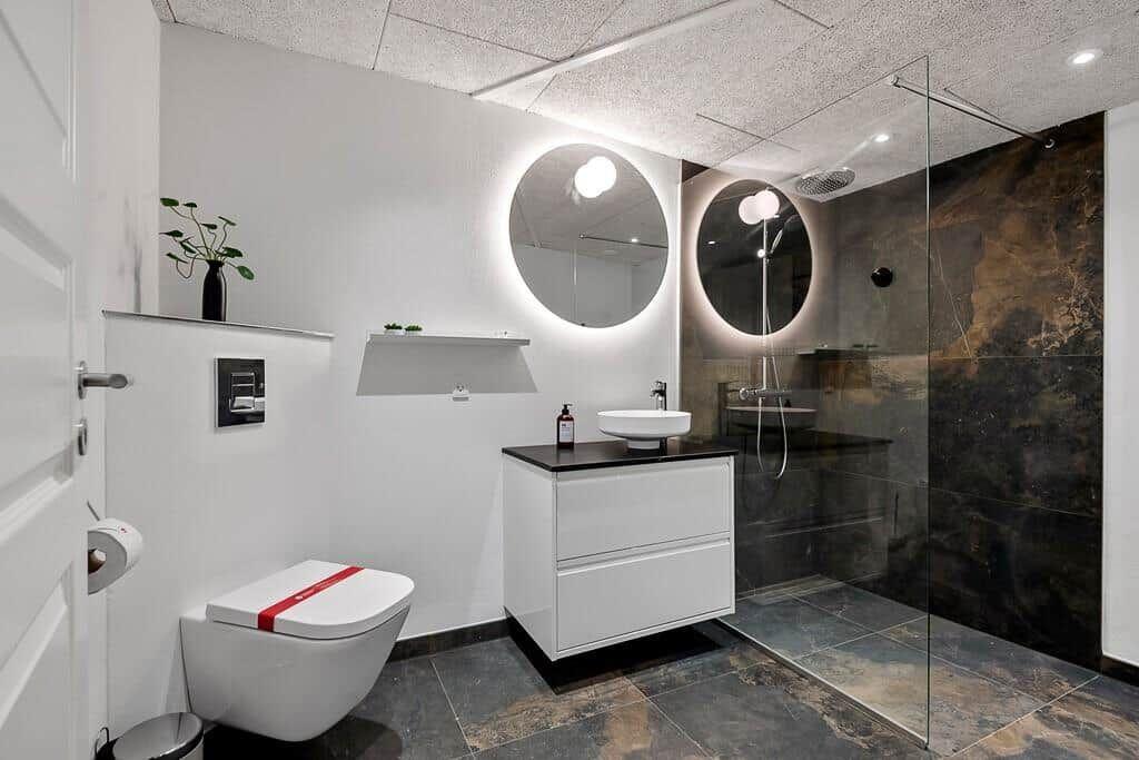 Modern bathroom with shower, sink, and toilet in minimalist design.