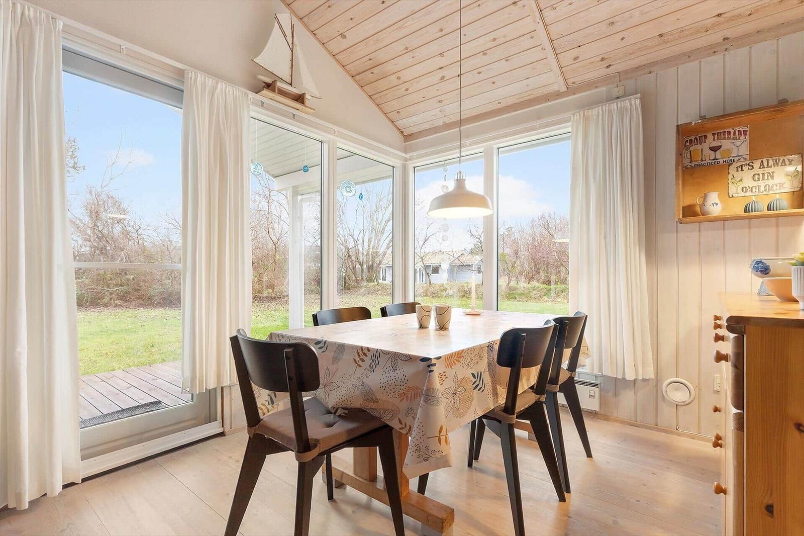 Dining room with table, chairs, and large windows to the garden
