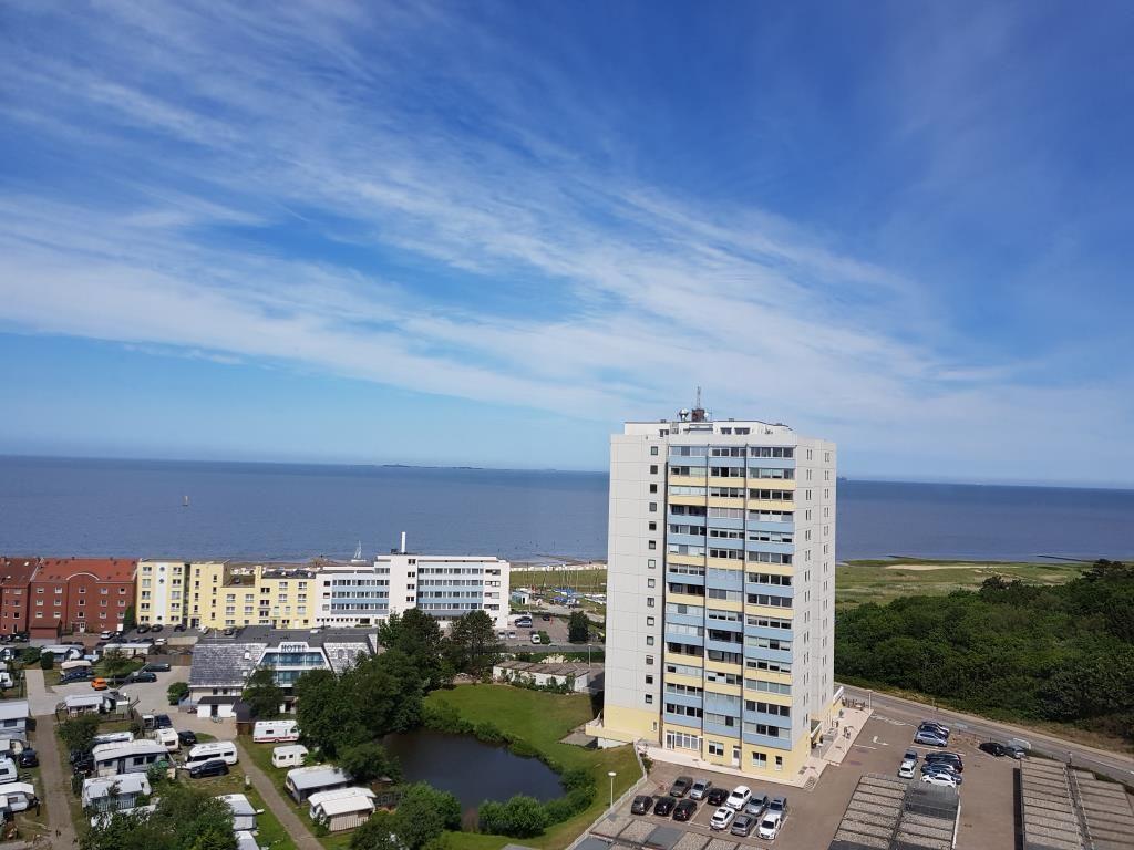 Hochhaus mit Blick auf Meer und Parkplatz. Umgebung mit Hotels und Wohnhäusern.