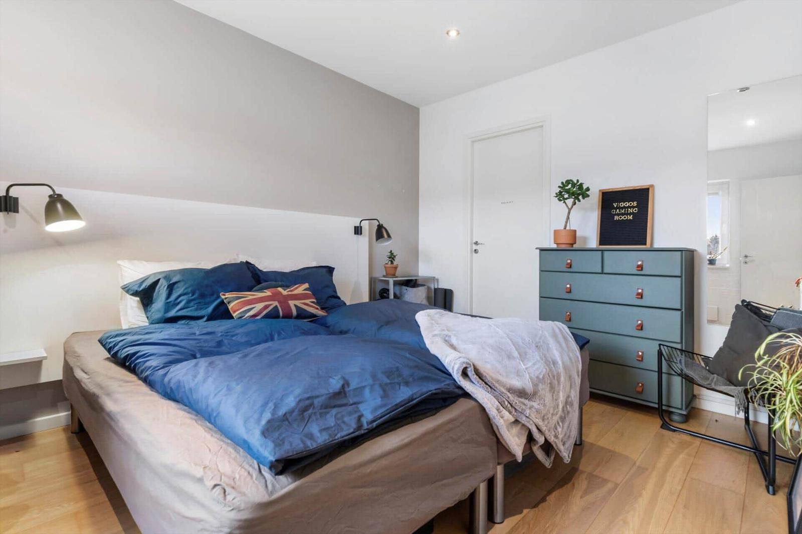 Bedroom with bed, nightstands, and dresser. Single window and mirror visible.