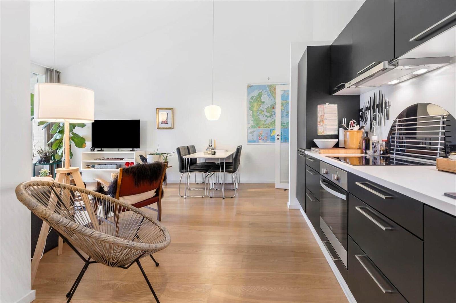 Kitchen with black cabinets and dining area with table and chairs.