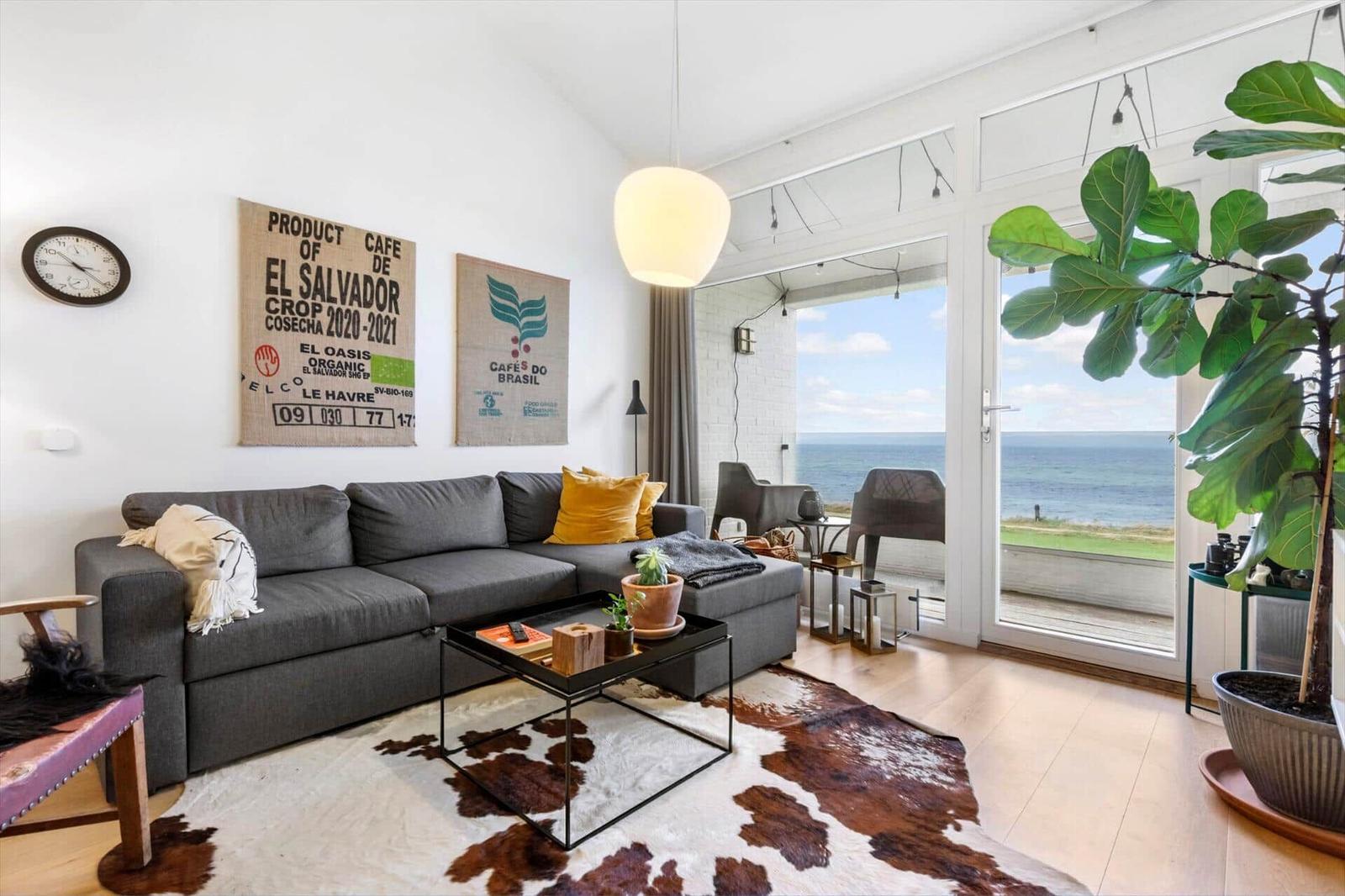 Living room with sofa, coffee table, and sea view.