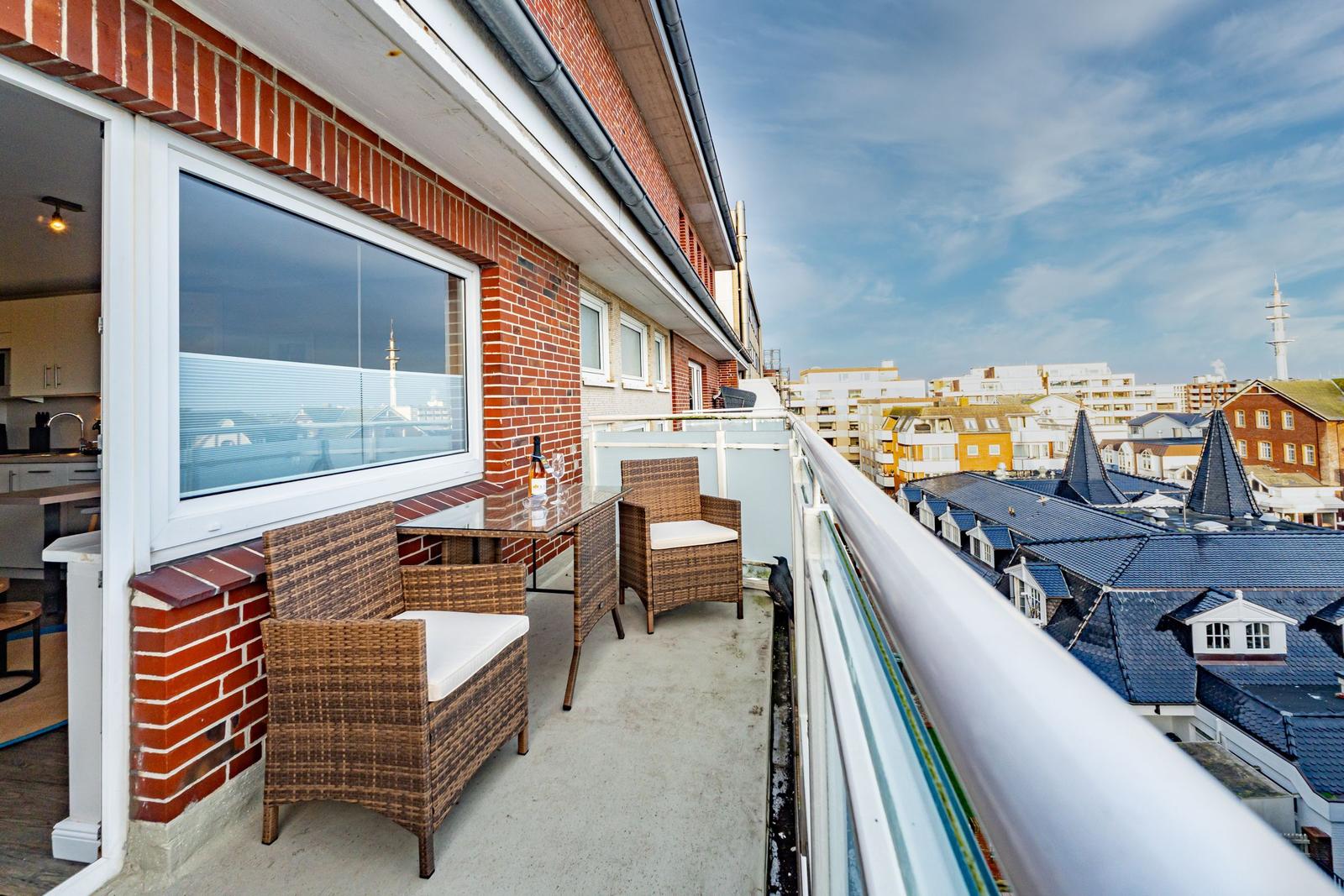 Terrasse mit Sitzgruppe und Stadtblick auf Dächer und Gebäude