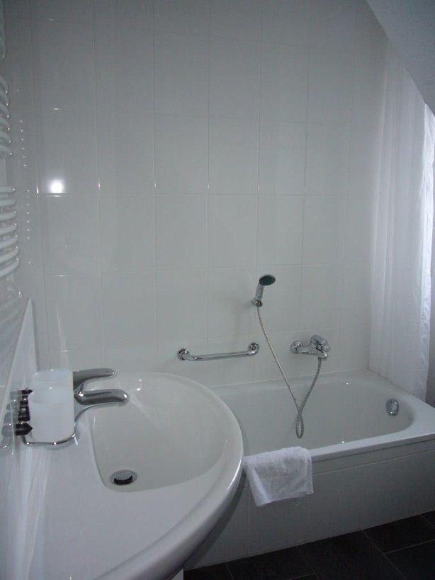 Bad mit Badewanne, Waschbecken und Handtuch.