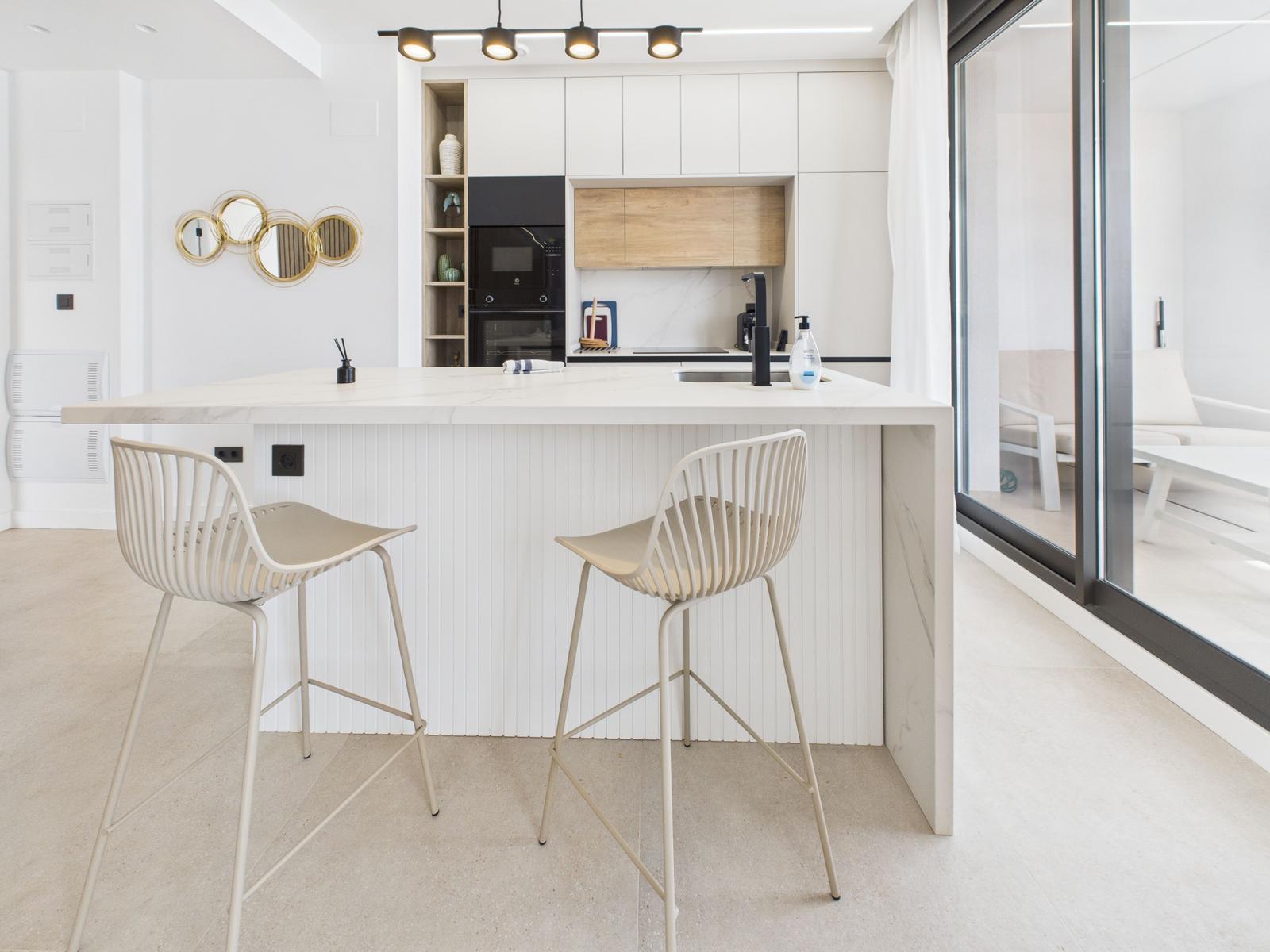 Kitchen with bar stools and view of living area