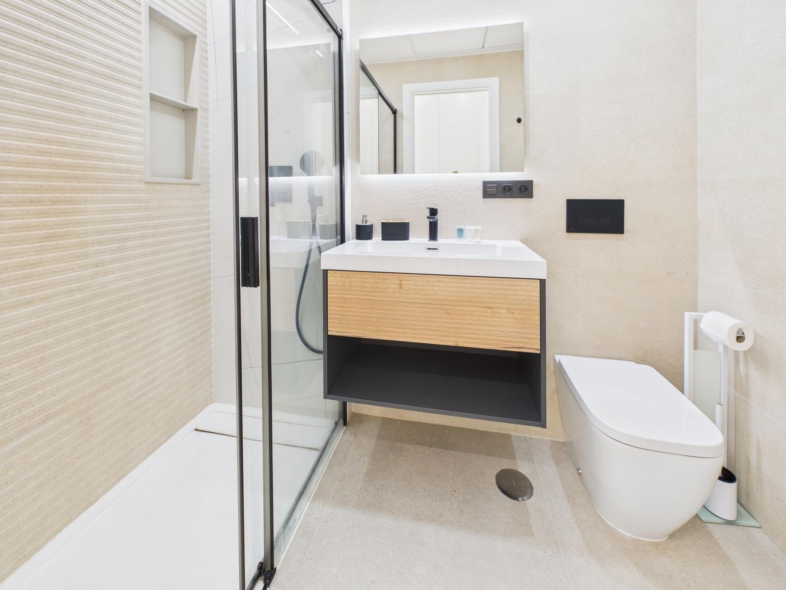 Bath with shower, sink and toilet. Wood and metal accents.