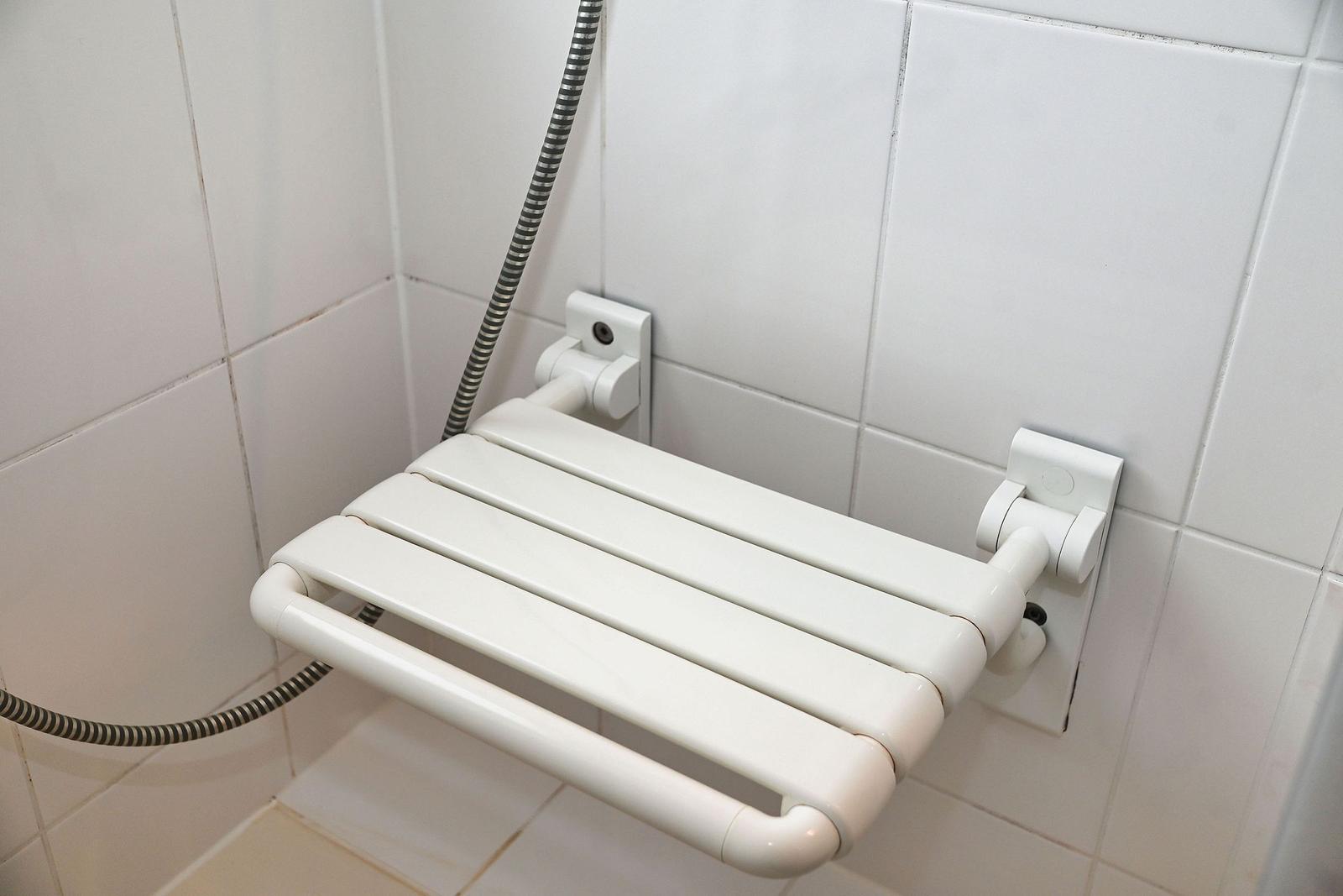 Duschbank mit Handlauf und Duschbrausehalterung an der Wand