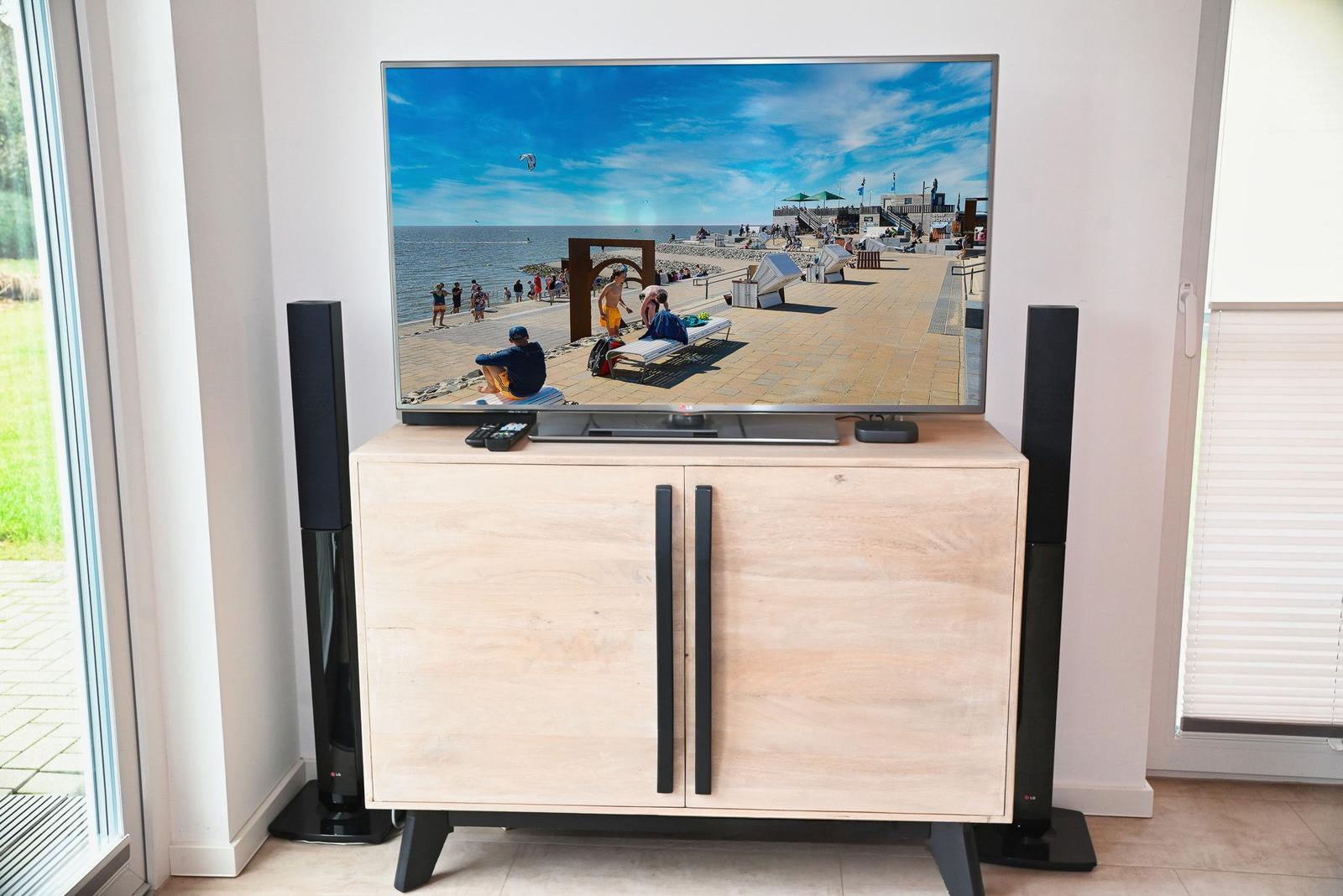 TV auf Holzboard mit Lautsprechern und Strandbild