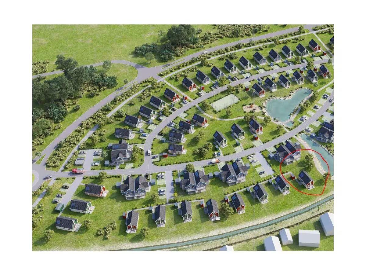 Ein Haus mit rotem Dach liegt am Ufer eines Flusses in einem grünen Wohngebiet.