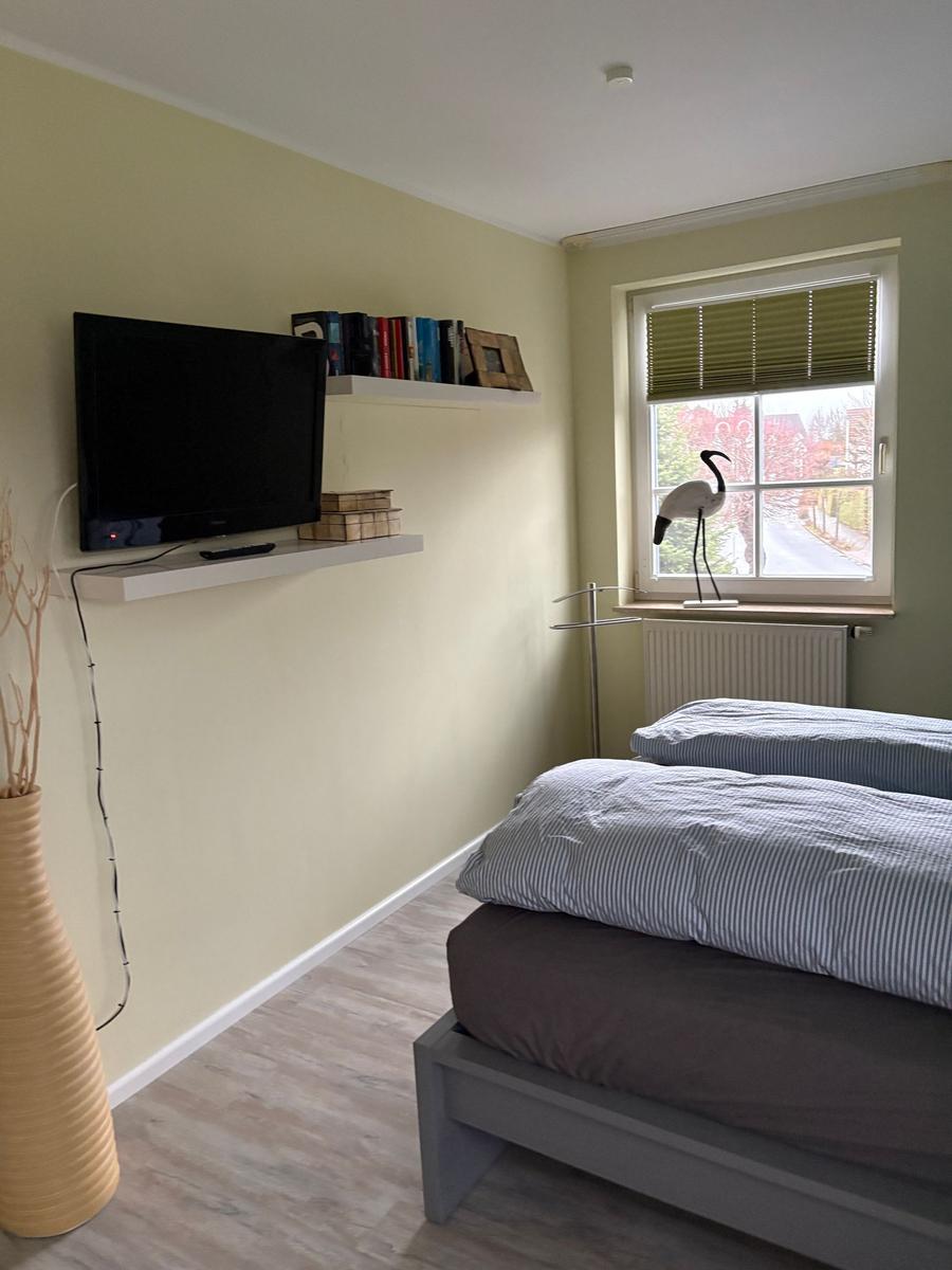 Schlafzimmer mit Bett, TV und Fenster mit Blick.