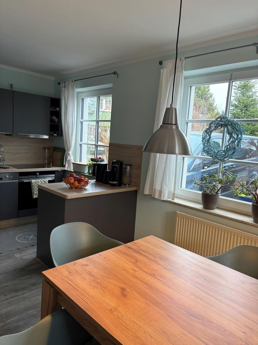 Küche mit Esstisch, Fenster und Pflanzen. Moderne Einrichtung mit Holztisch.