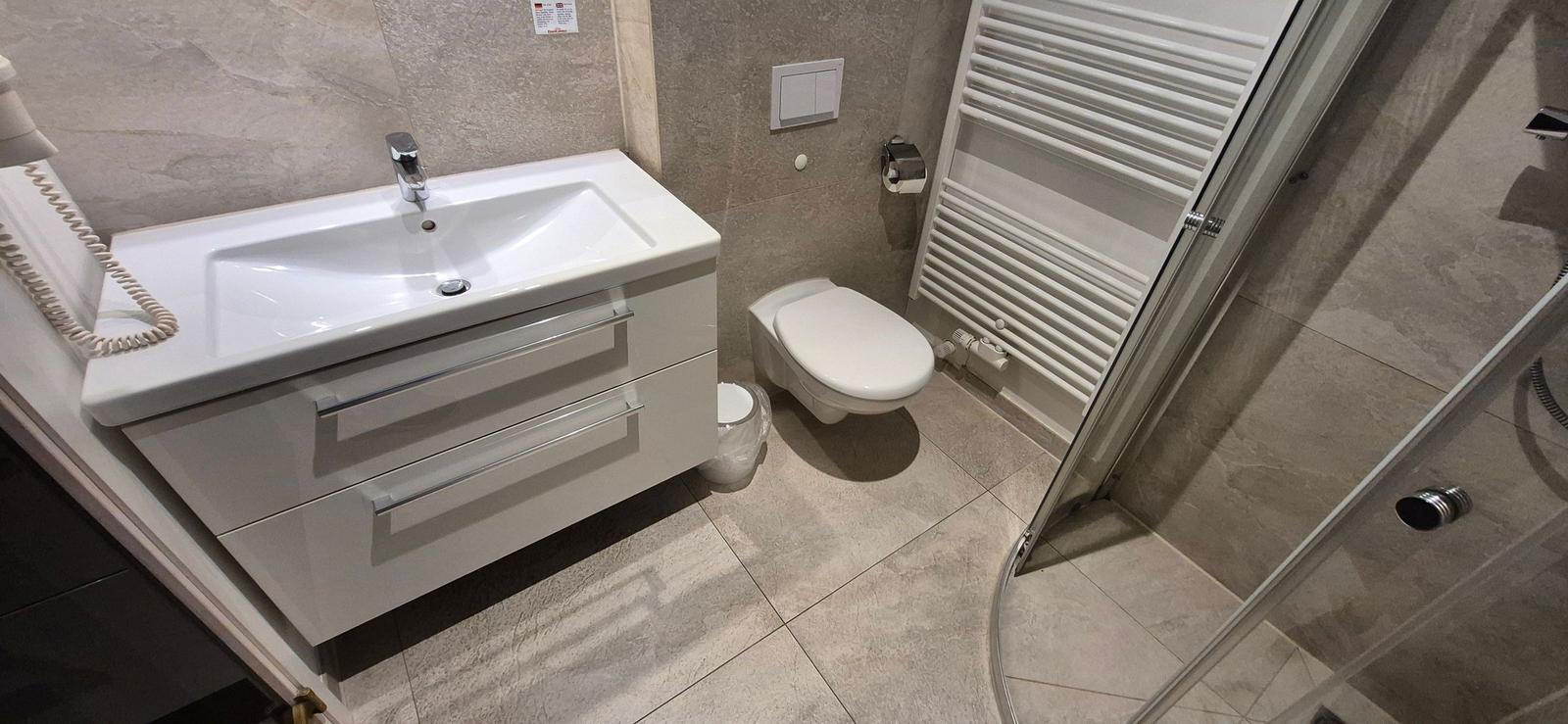 Badezimmer mit Waschbecken, Toilette und Dusche