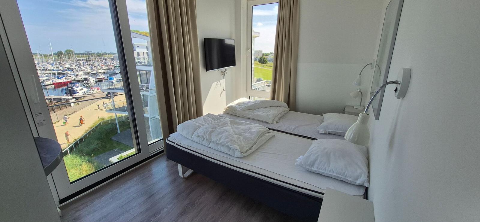 Zimmer mit Doppelbett, TV und Blick auf Hafen