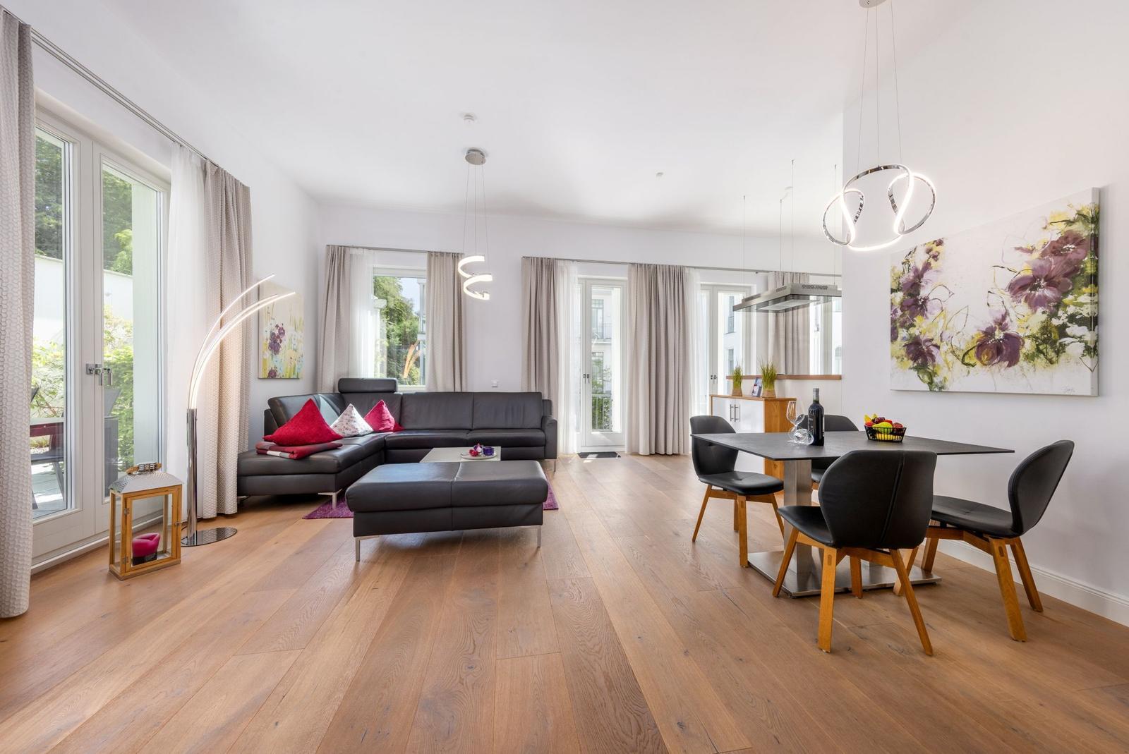 Wohn- und Essbereich mit Leder Sofa, Esstisch und Holzboden.