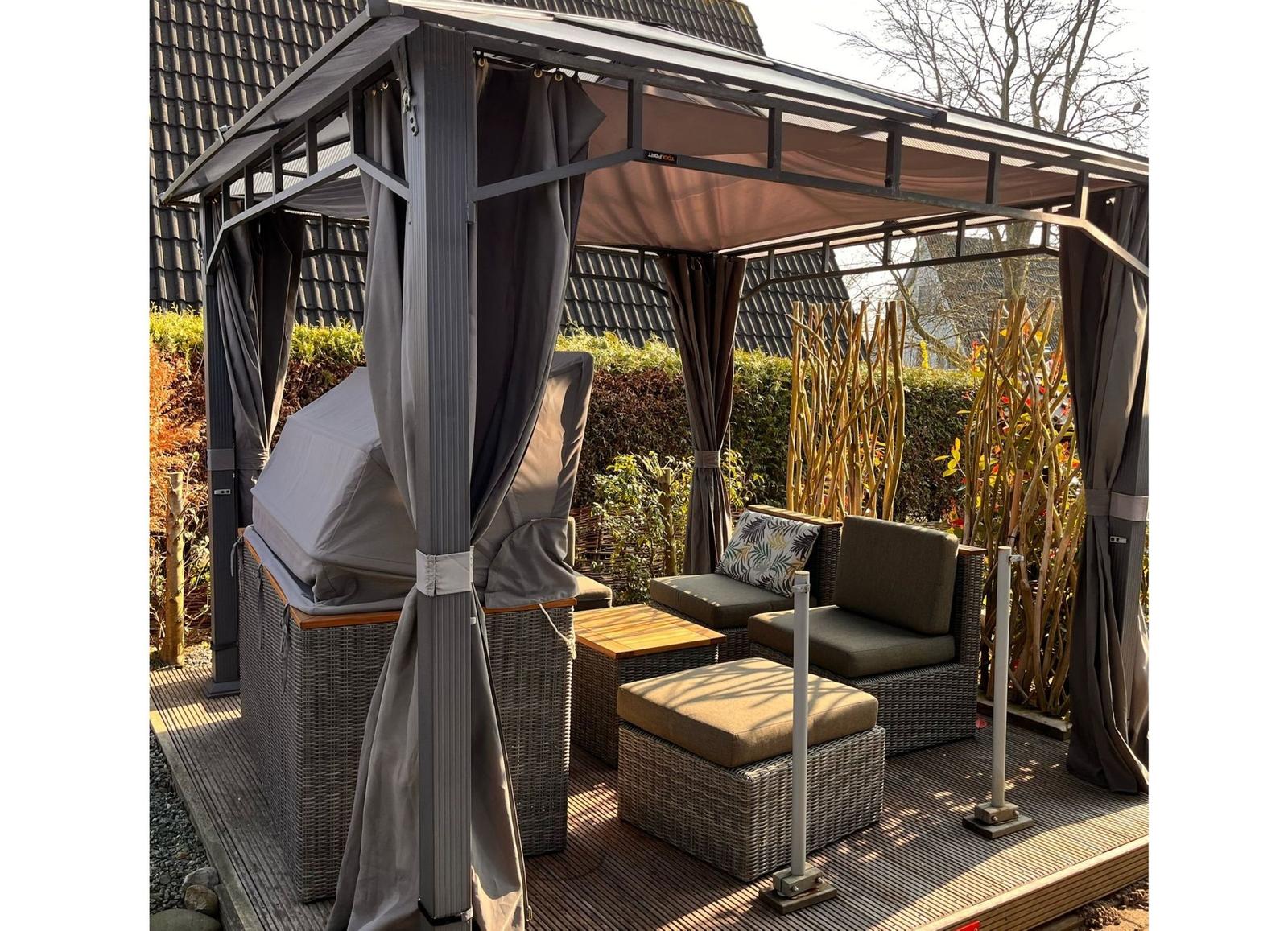 Terrasse mit Pavillon, Sitzgruppe und Grill unter schattigem Dach.