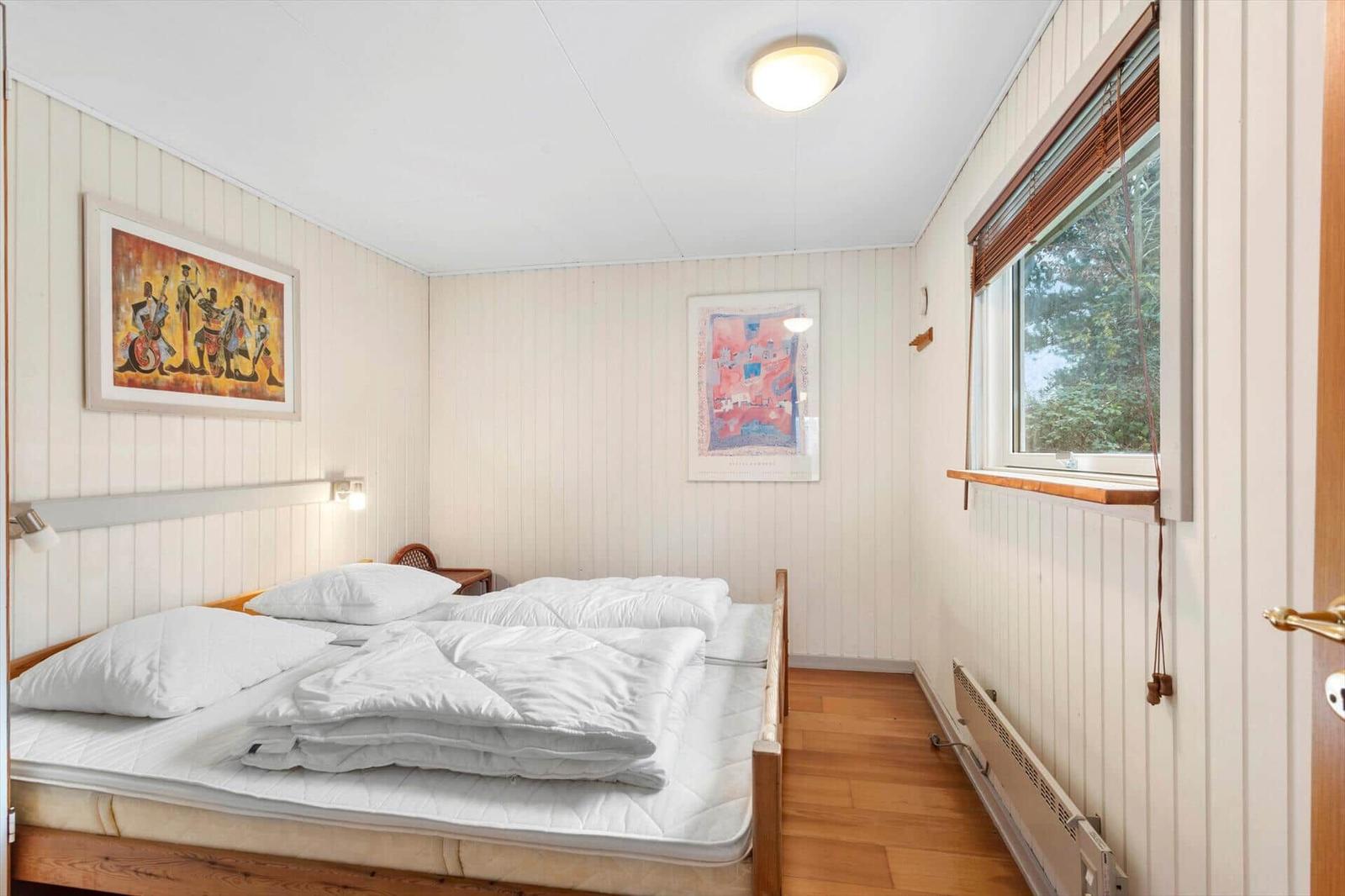 Bedroom with bed, window, and wall art