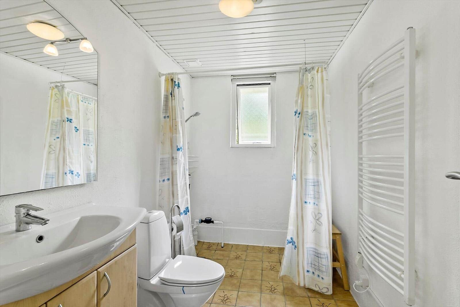 Bathroom with shower, toilet, sink, and heater.