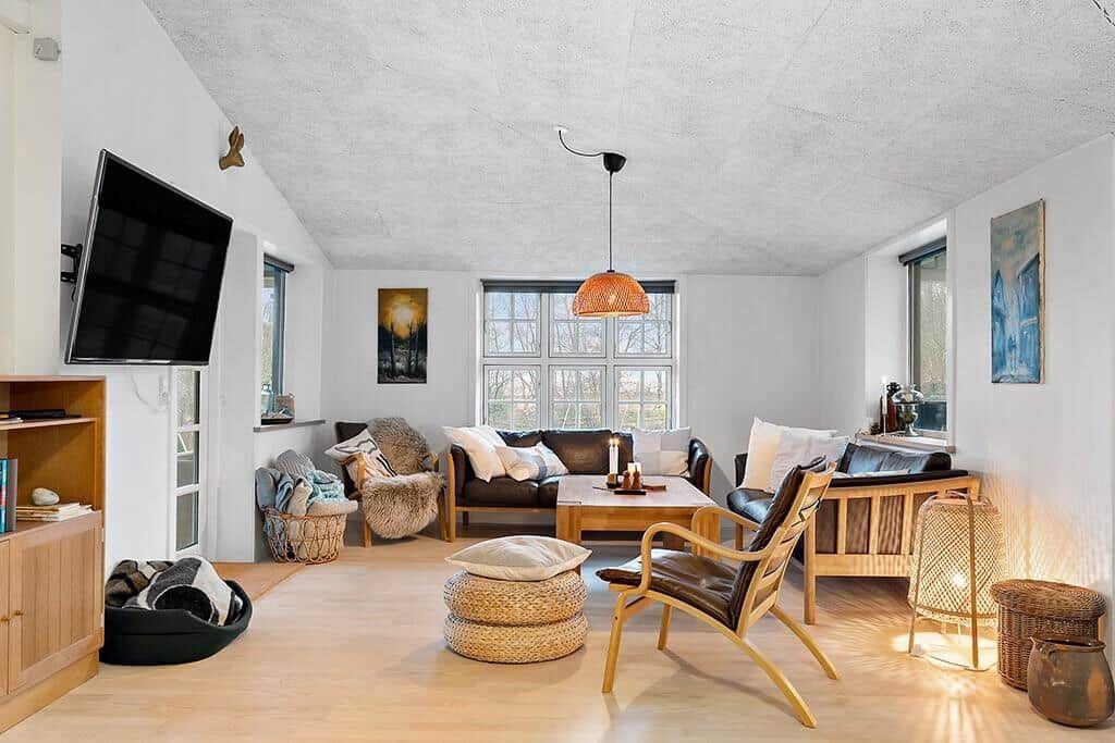 Living room with sofa, chair, and TV mounted on the wall.