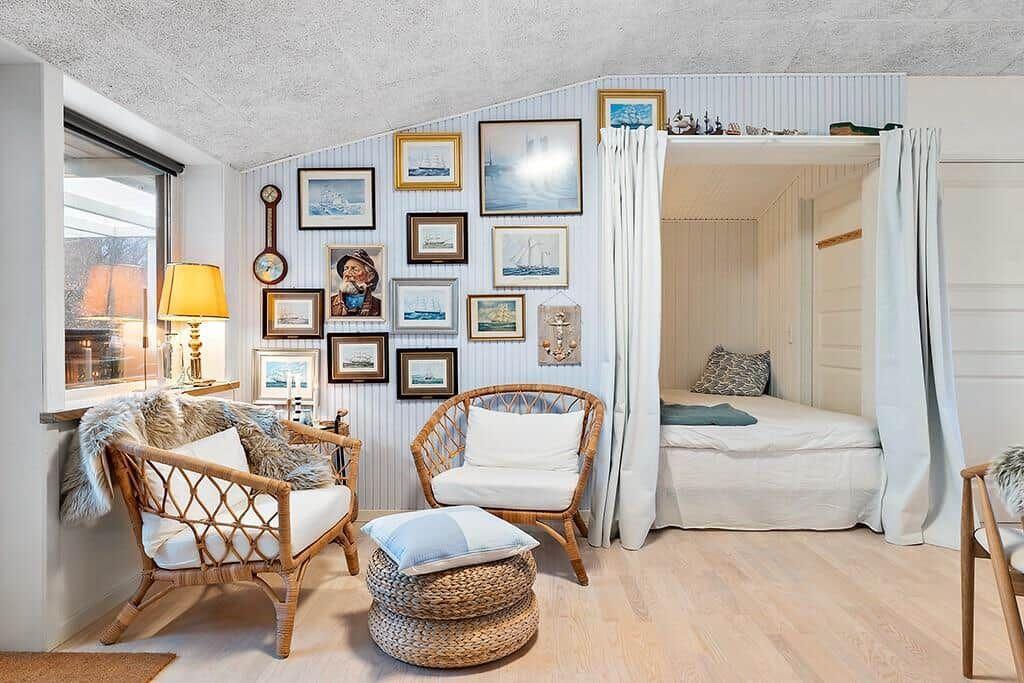 Room with rattan furniture, wall art, and bed under canopy.