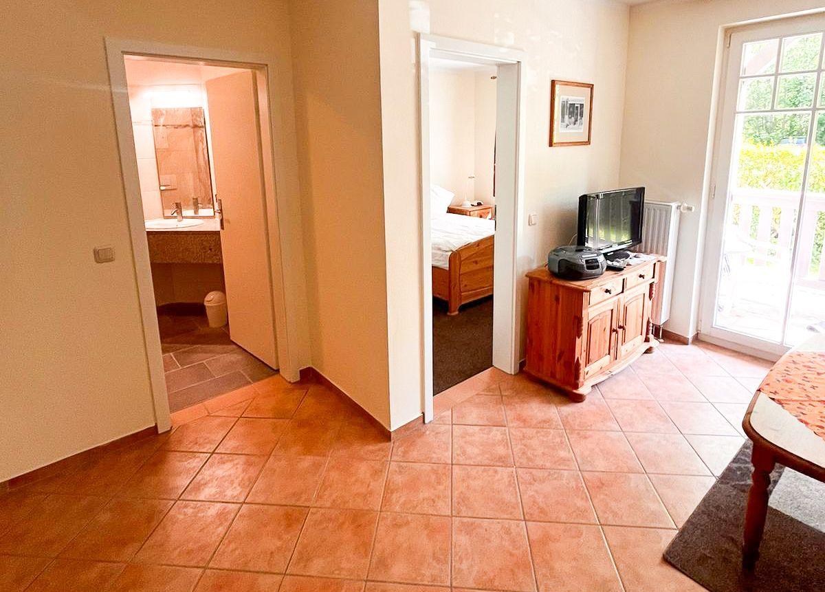 Wohnbereich mit TV, Schlafzimmer und Bad im Hintergrund.